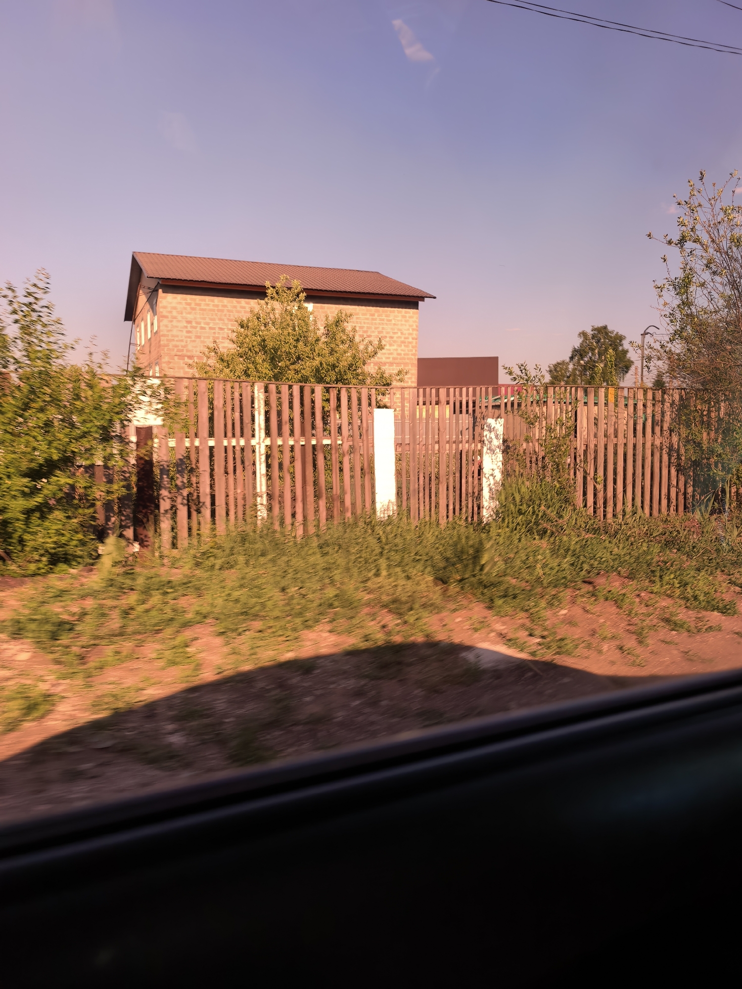 Brick house behind wooden fence observed in Sterlitamak, Russia