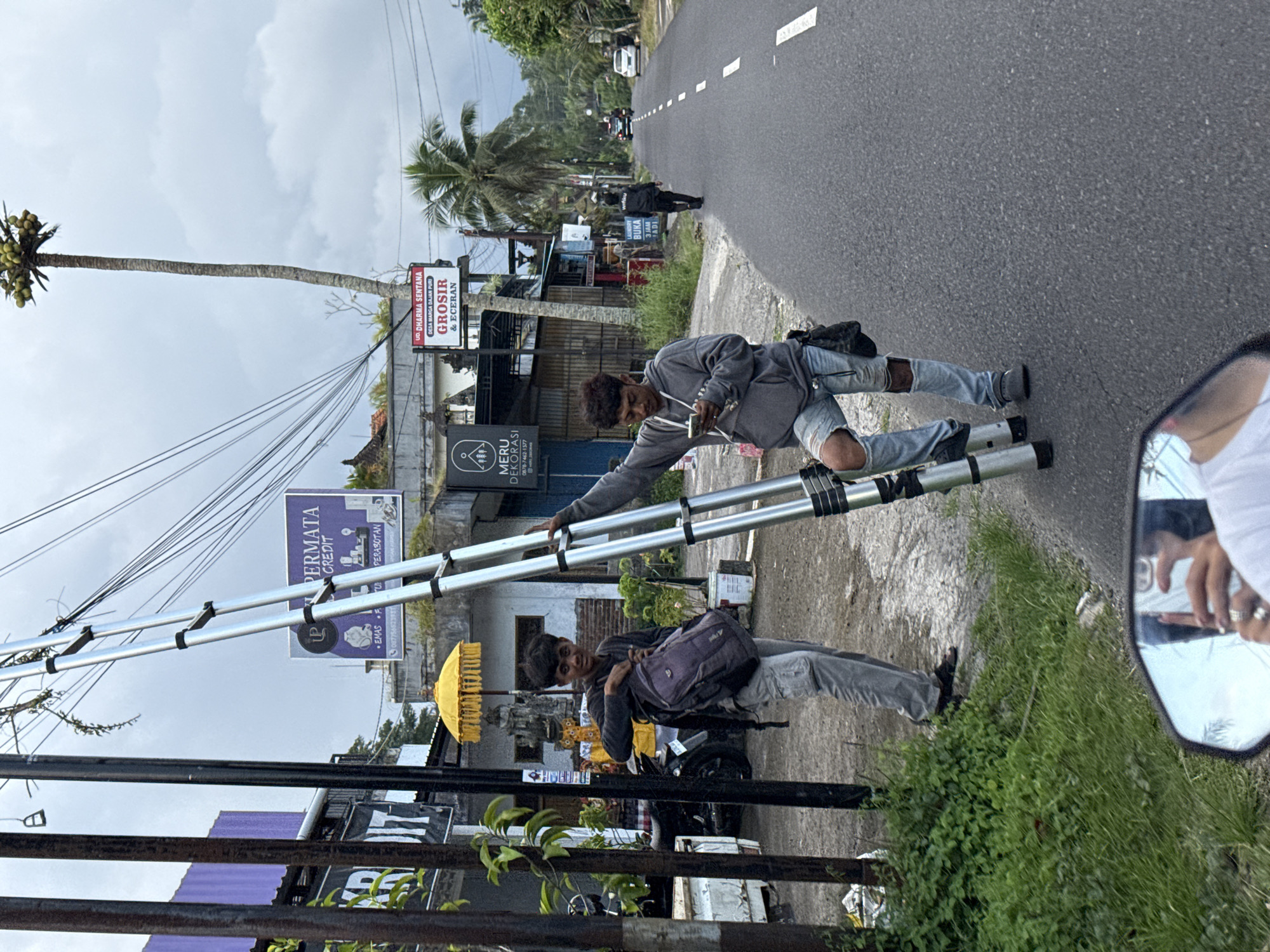 People gather on street handling metal structure in Marga