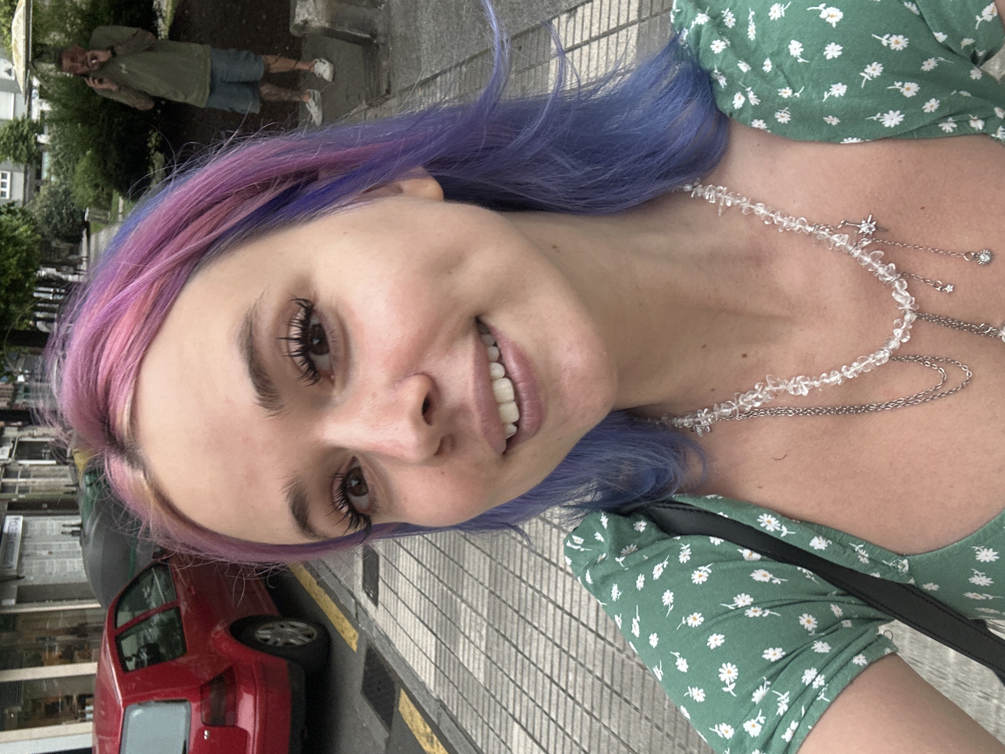 Woman takes selfie on sidewalk in Gijón, Spain