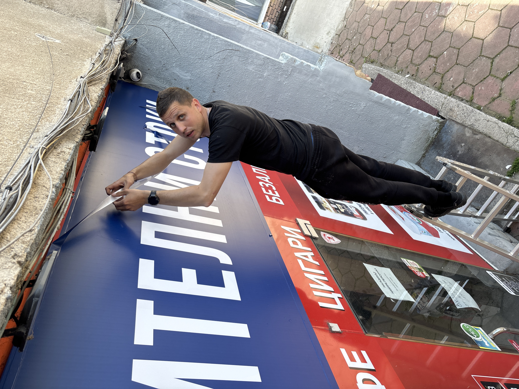 Man removes tape from tobacco store sign in Plovdiv