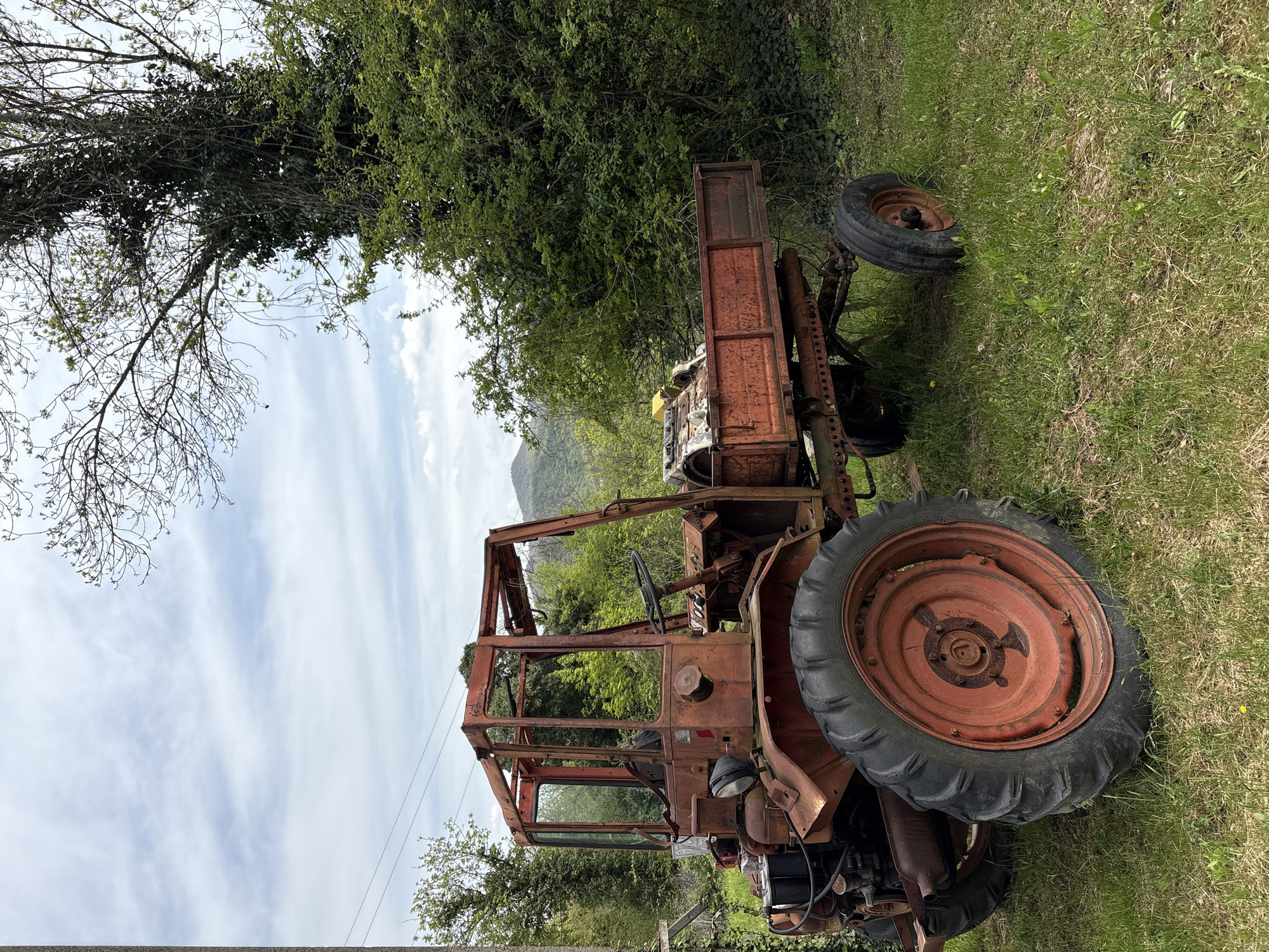 Rural Russian village scenes captured: abandoned tractors, waterfalls, buildings