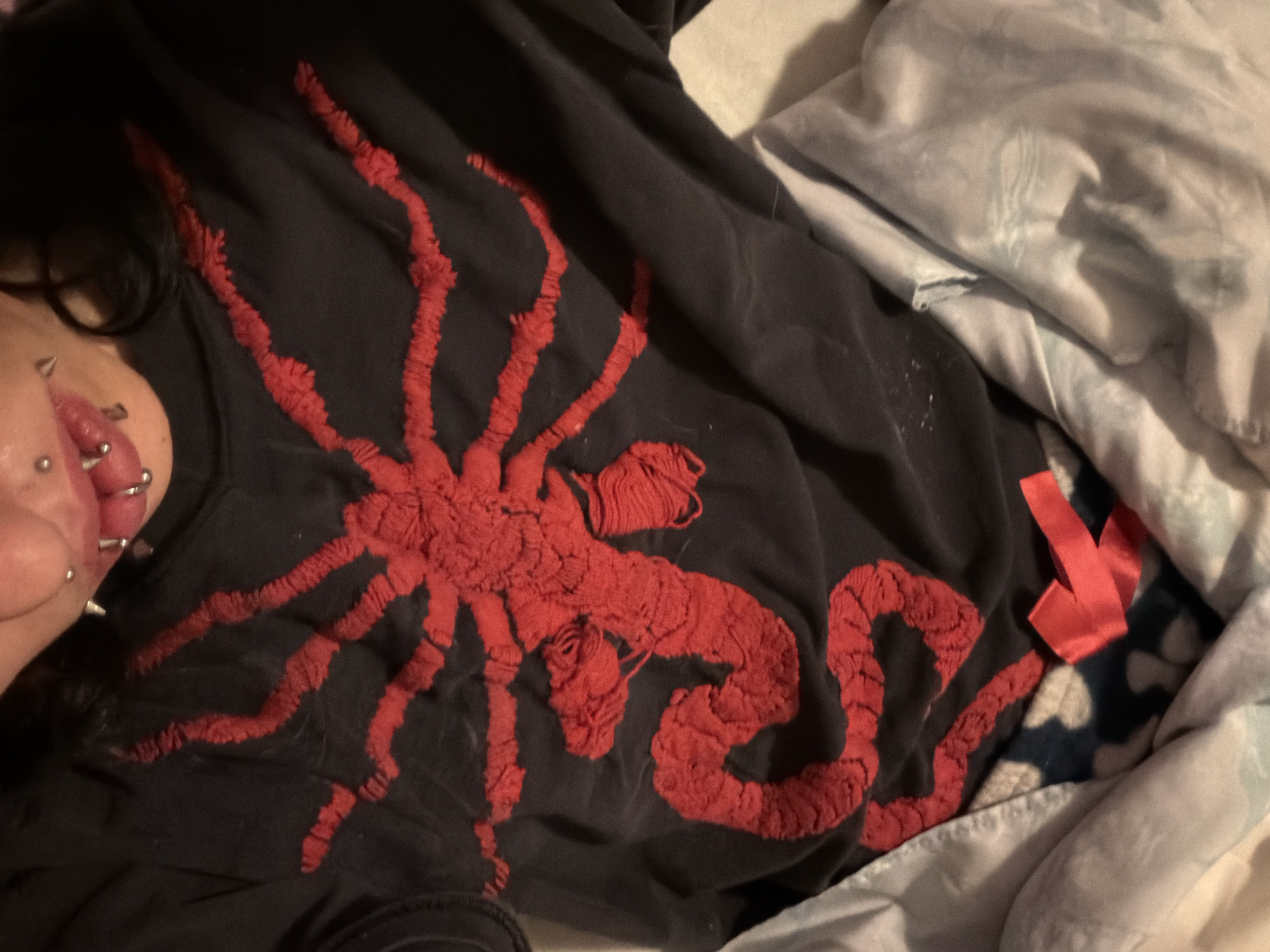 Person with piercings smokes in bed in Sofia