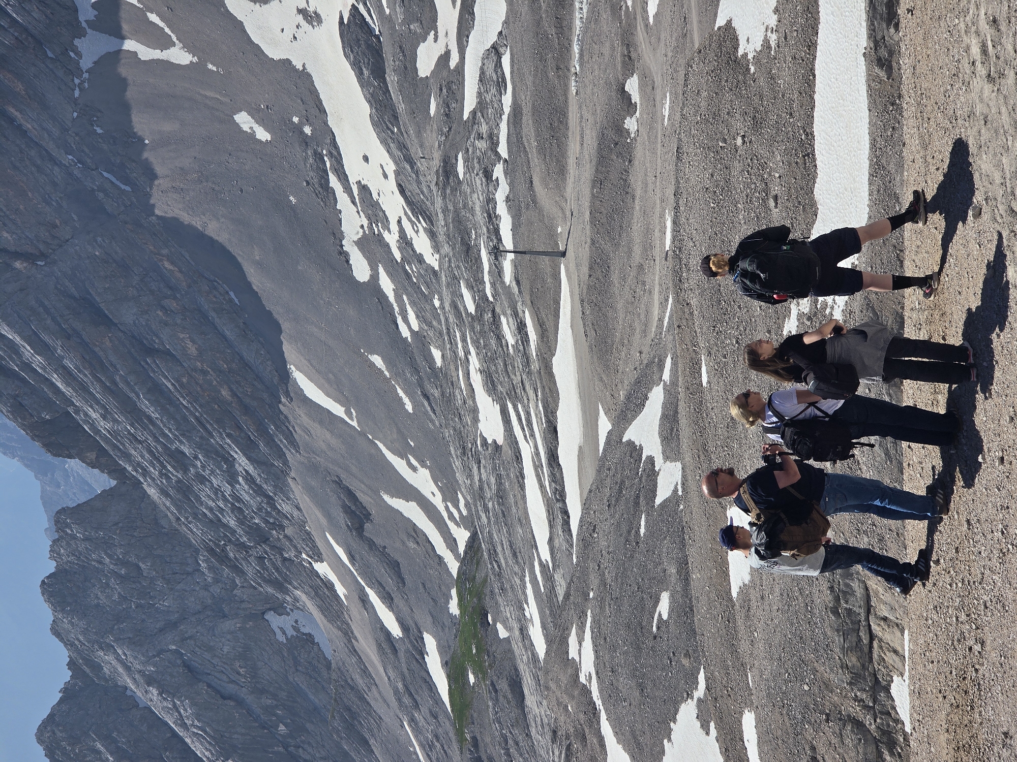 Hikers and snow groomers on a clear morning in the Bavarian Alps