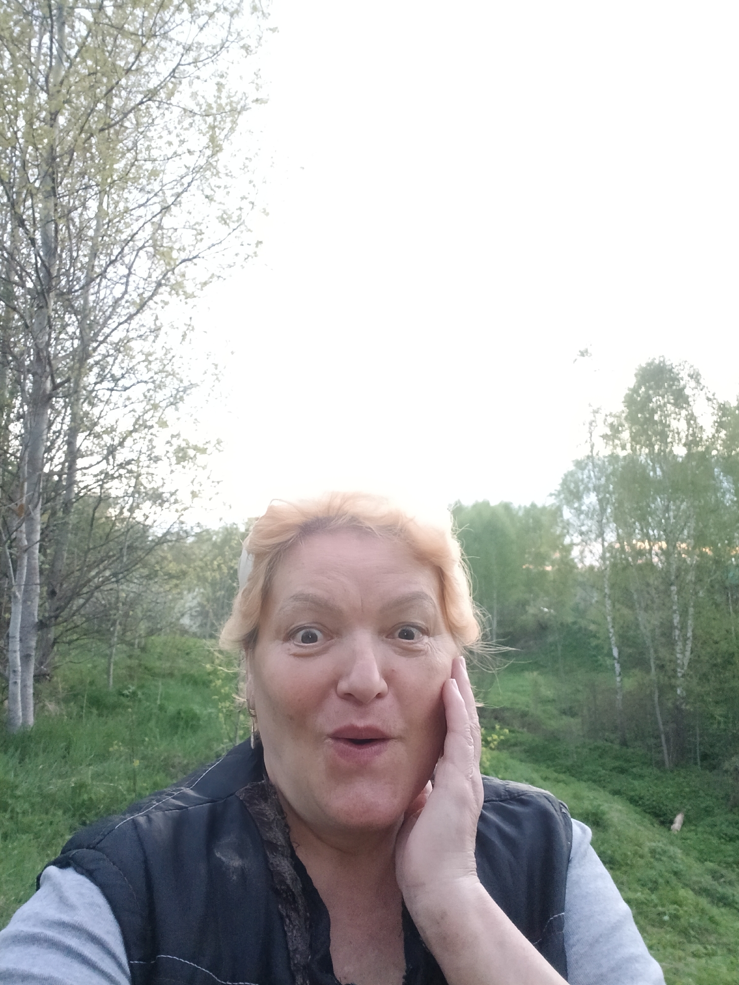 Woman documents rural landscape during evening walk in Russian village