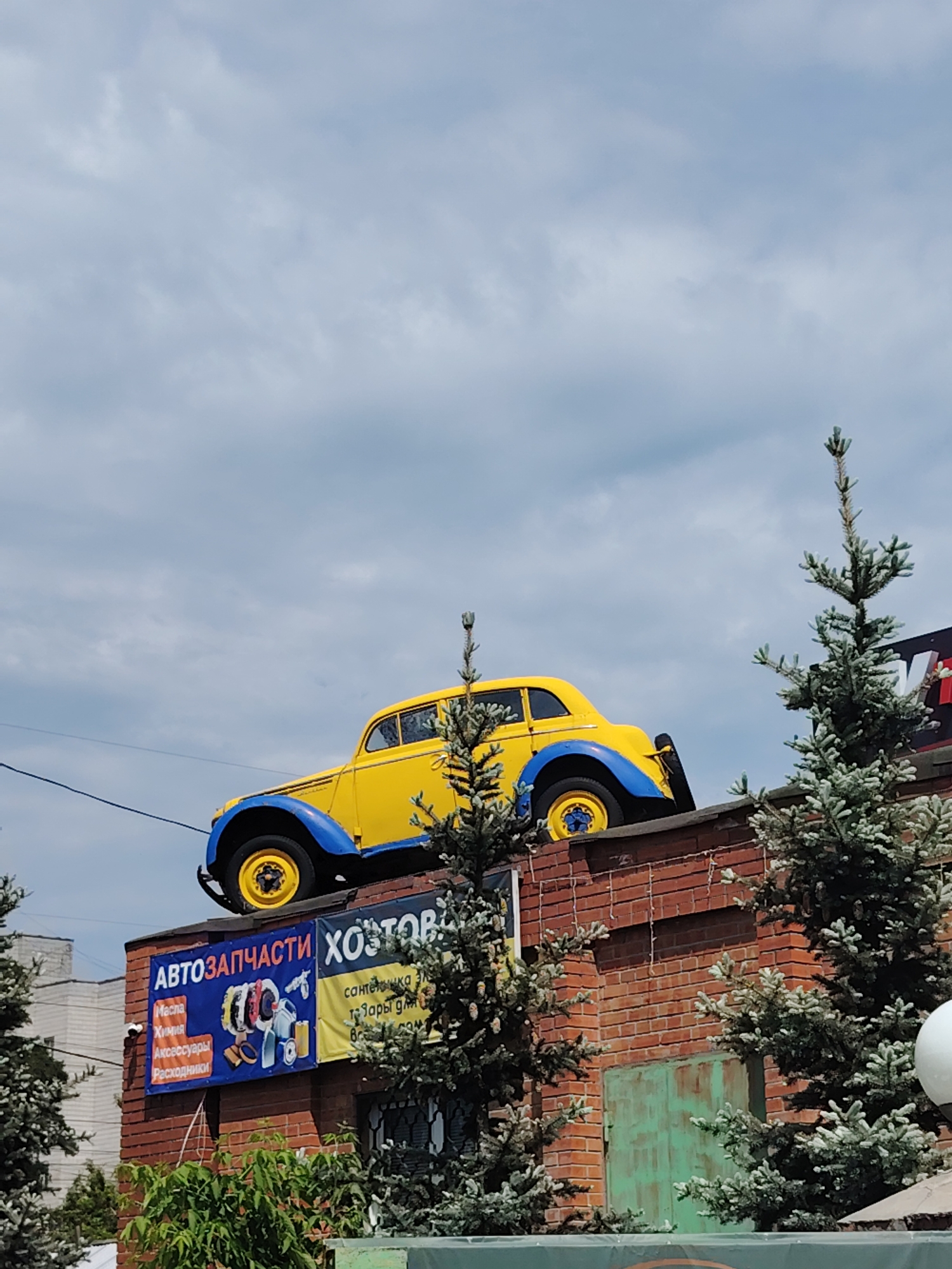 Vintage car serves as rooftop advertisement for autoparts shop