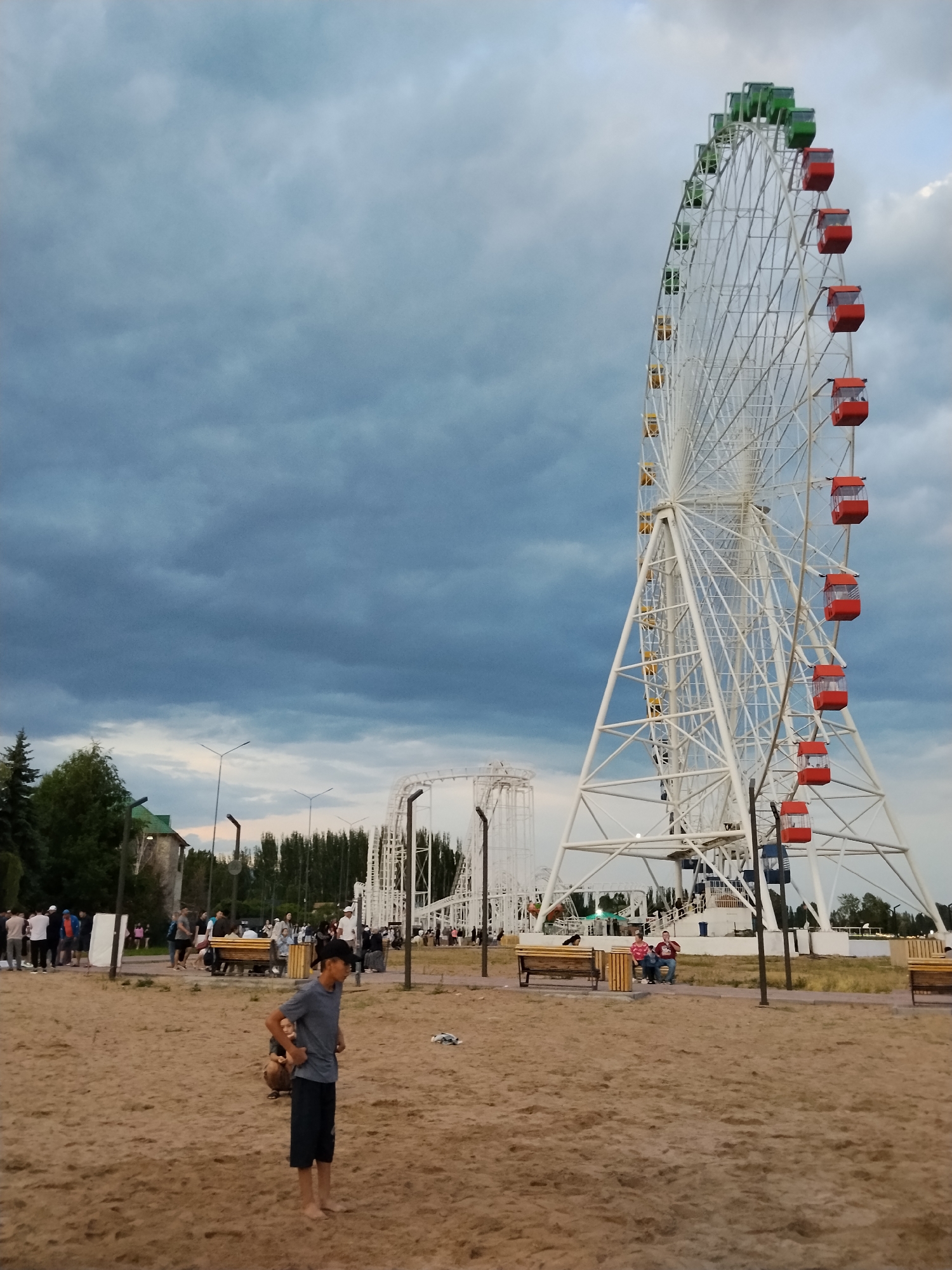 Ferris wheel, beach, and open water on a grey afternoon