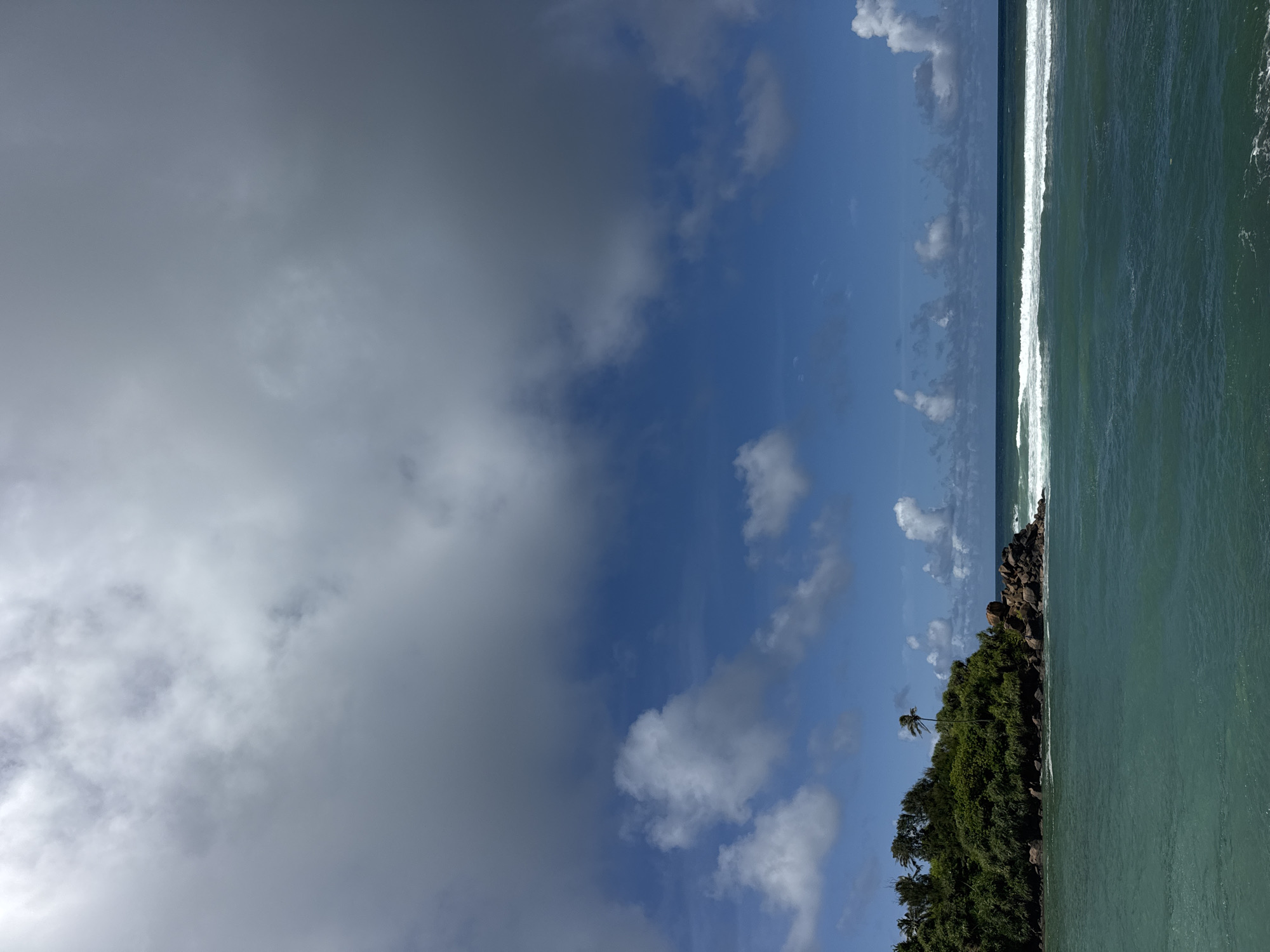 Turquoise water and a green rocky island off Goviyapana