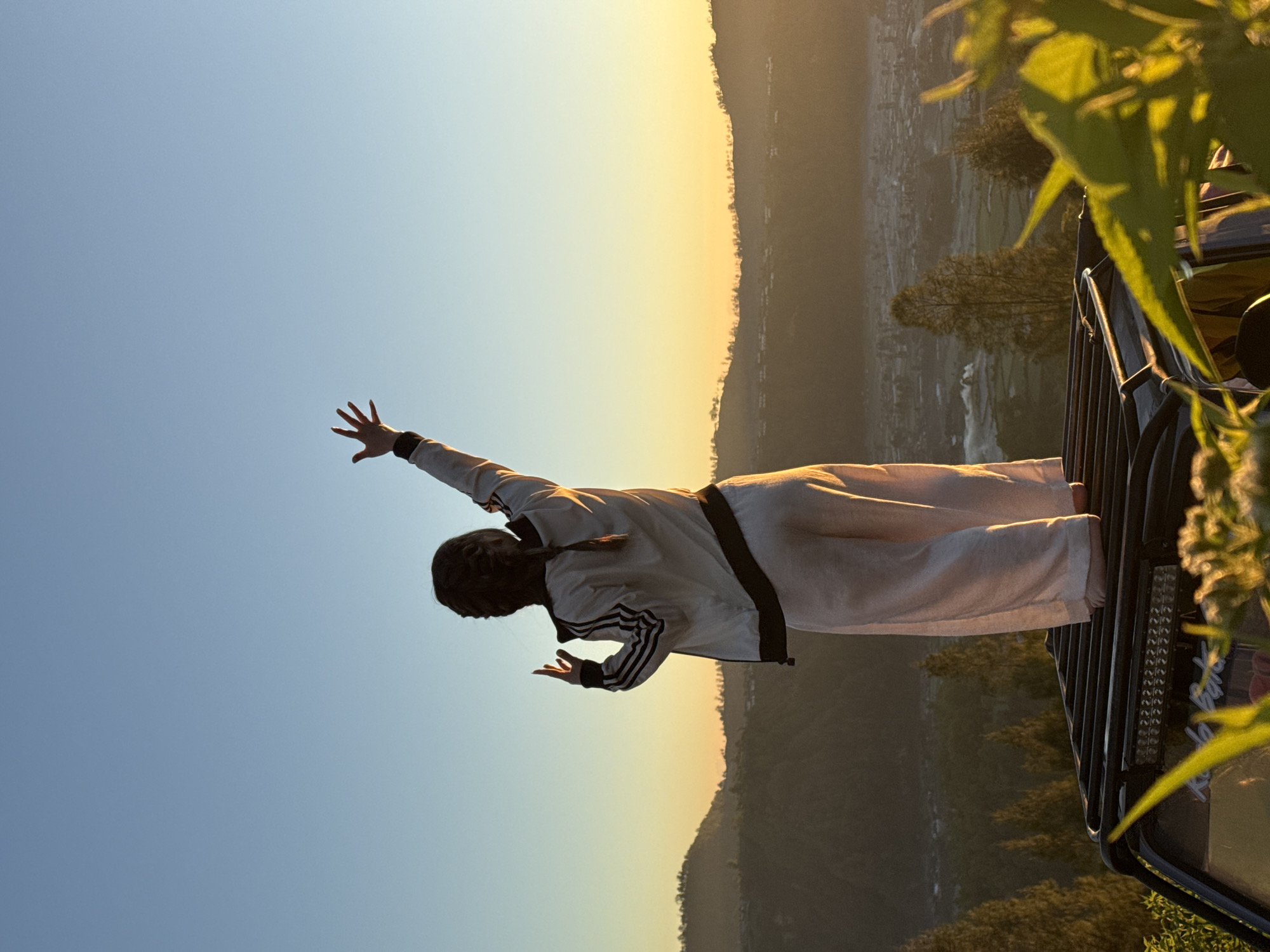 Arms raised at sunrise above Kintamani's volcanic highland views