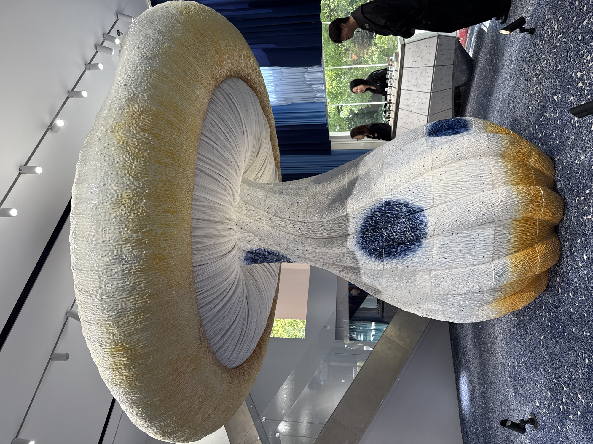 Urban scenes documented: mushroom sculpture, woman in denim, brick building