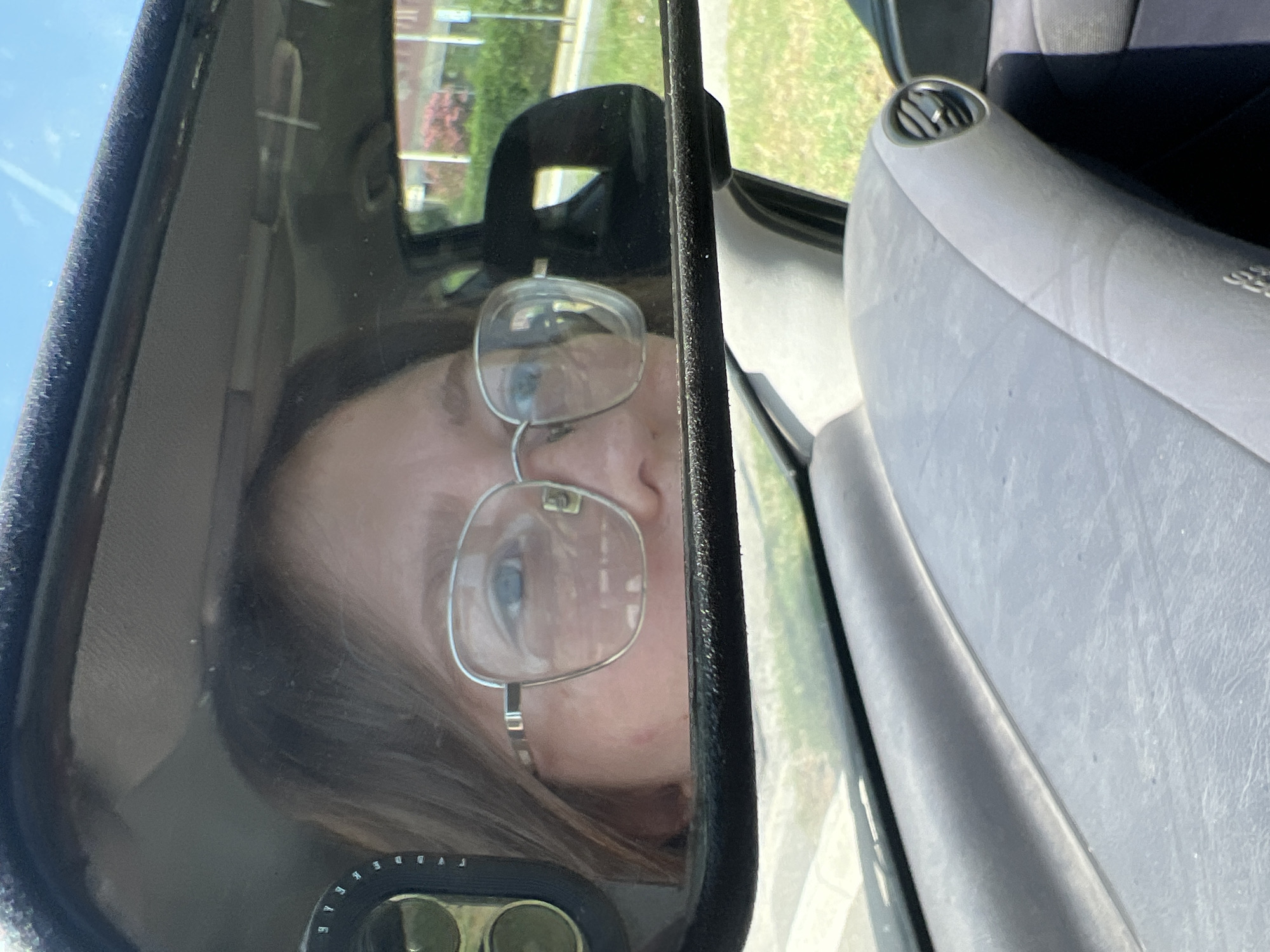 Person with glasses spotted in car rearview mirror in Podgorica