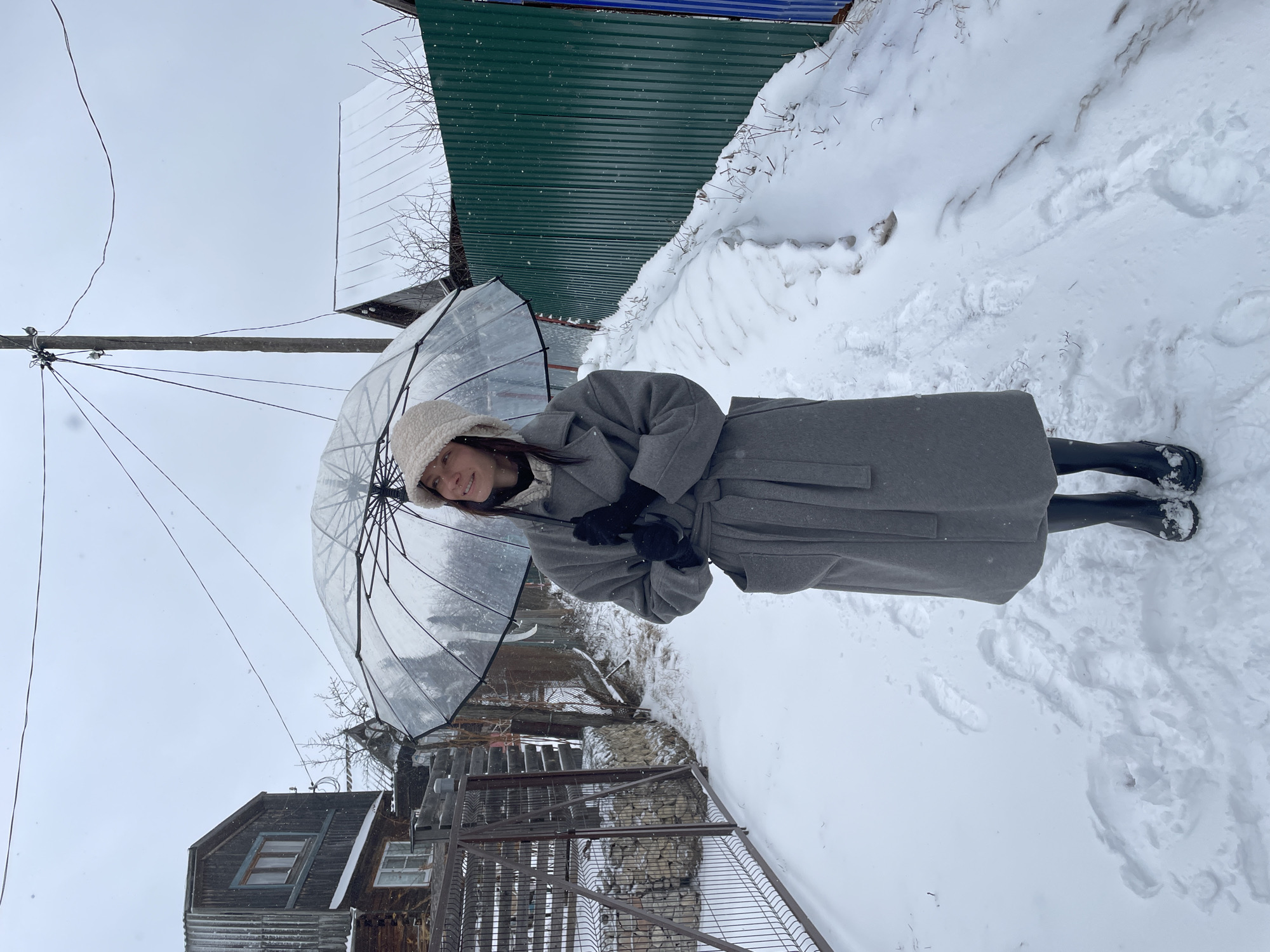 Person with umbrella walks through snow in Oktyabrsky, Russia