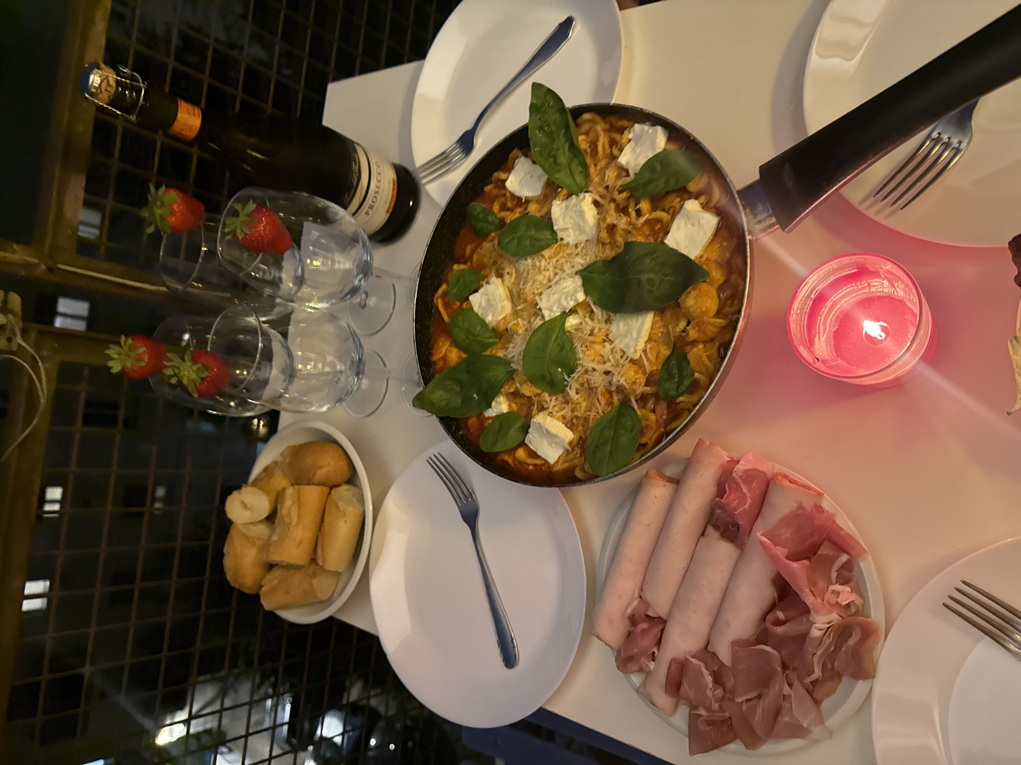 Candlelit pasta dinner captured in Milan evening setting
