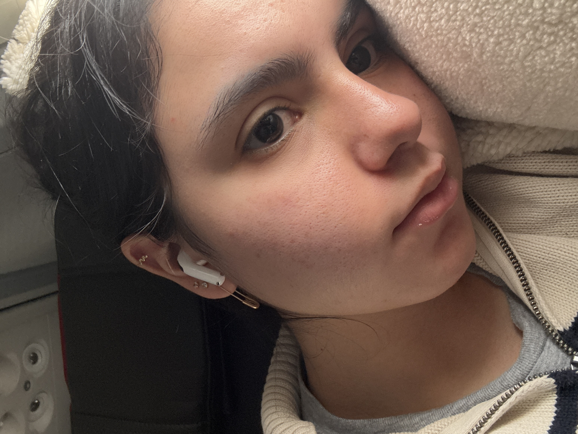 Young woman photographed wearing earbuds and jewelry in Maramec