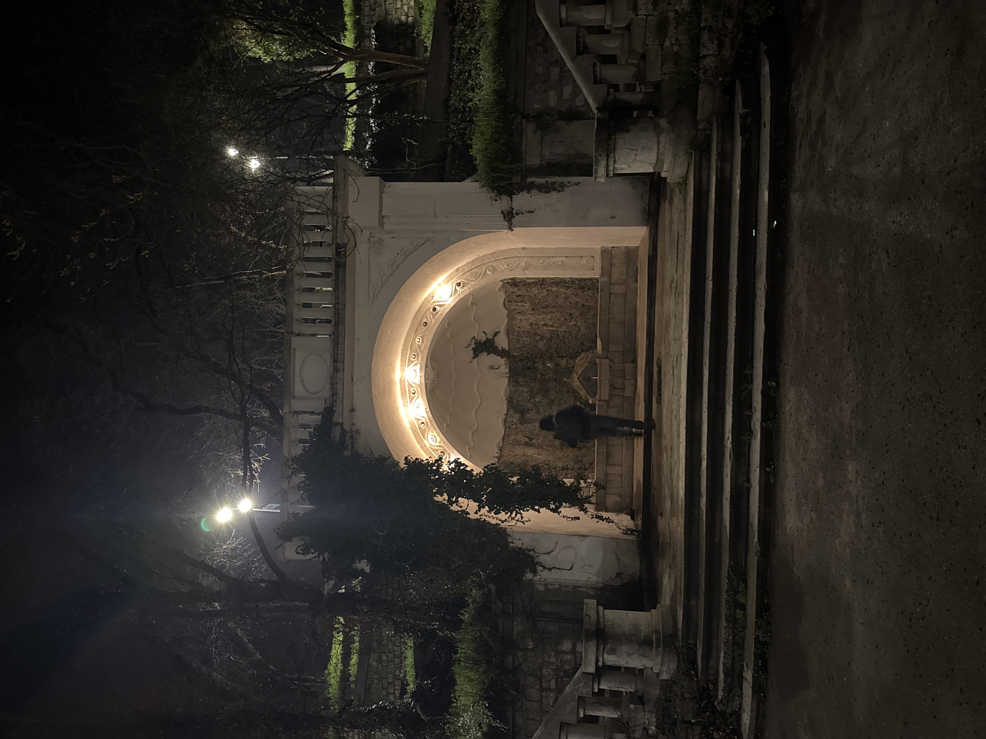 Person stands by illuminated historic architecture in Varna