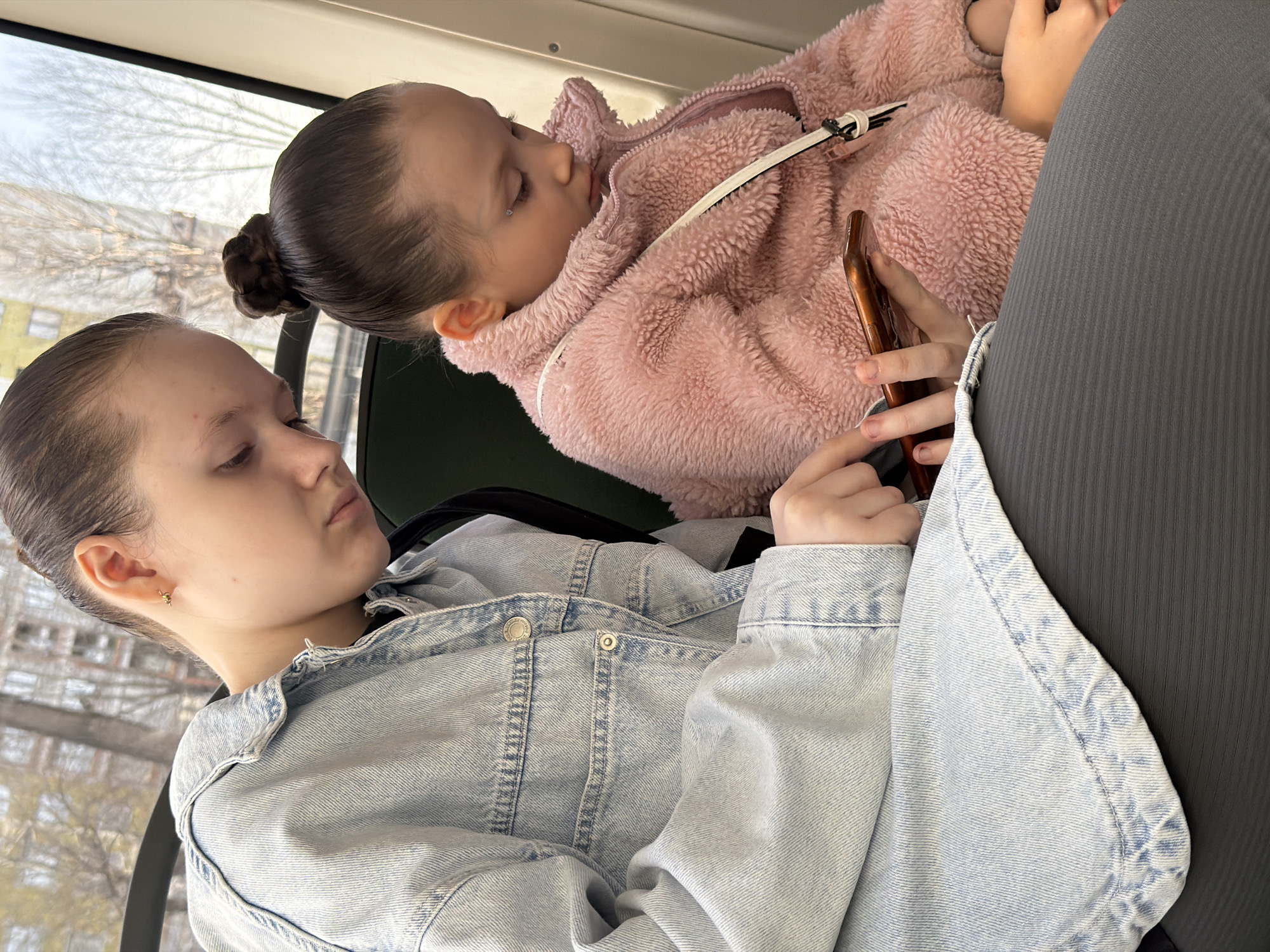 Two girls ride bus together in Perm, Russia