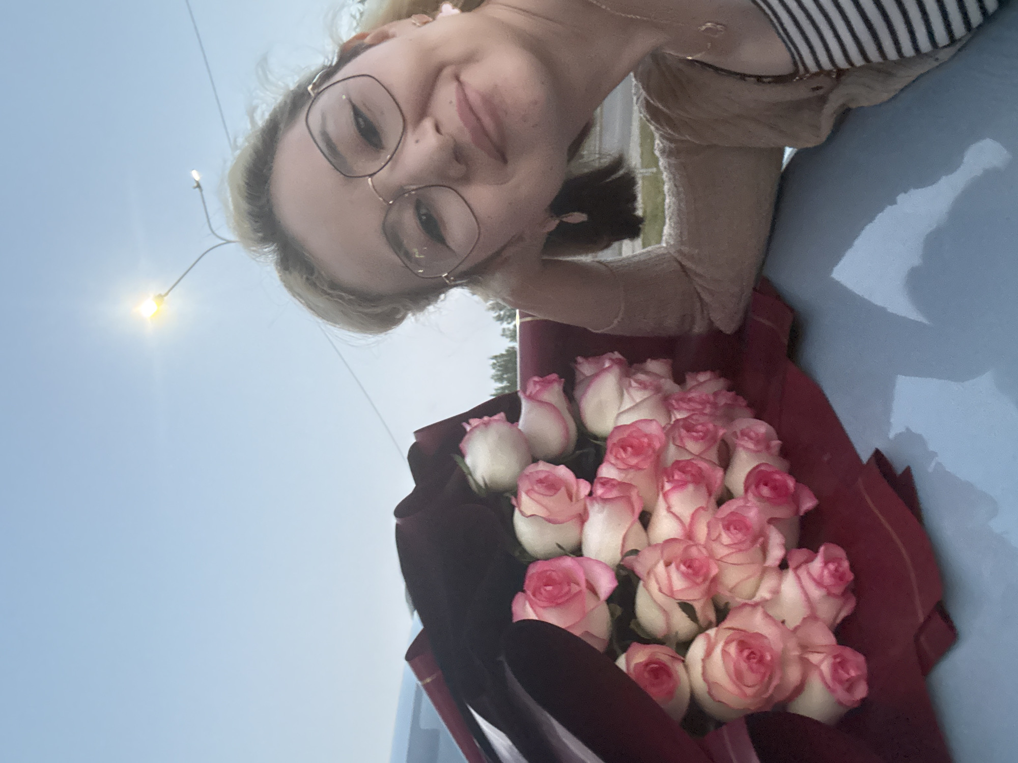 Woman receives rose bouquet in Astana, poses with car