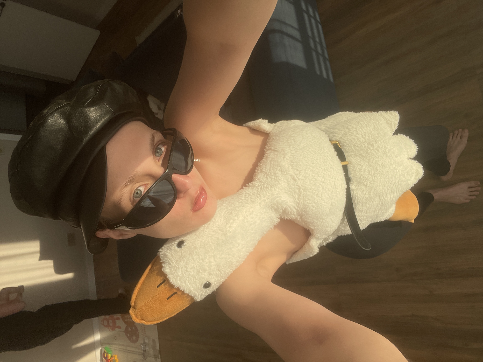 Person poses with plush goose indoors in Russian village
