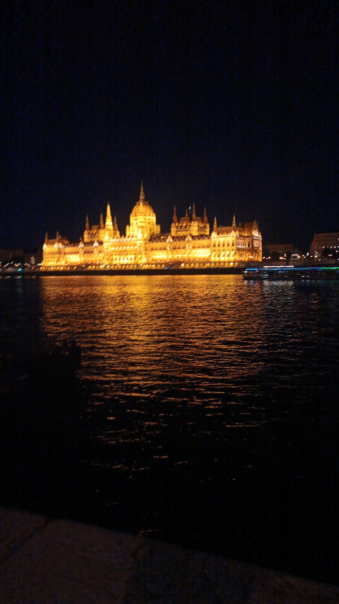 Hungarian Parliament Building illuminated at night along Danube River