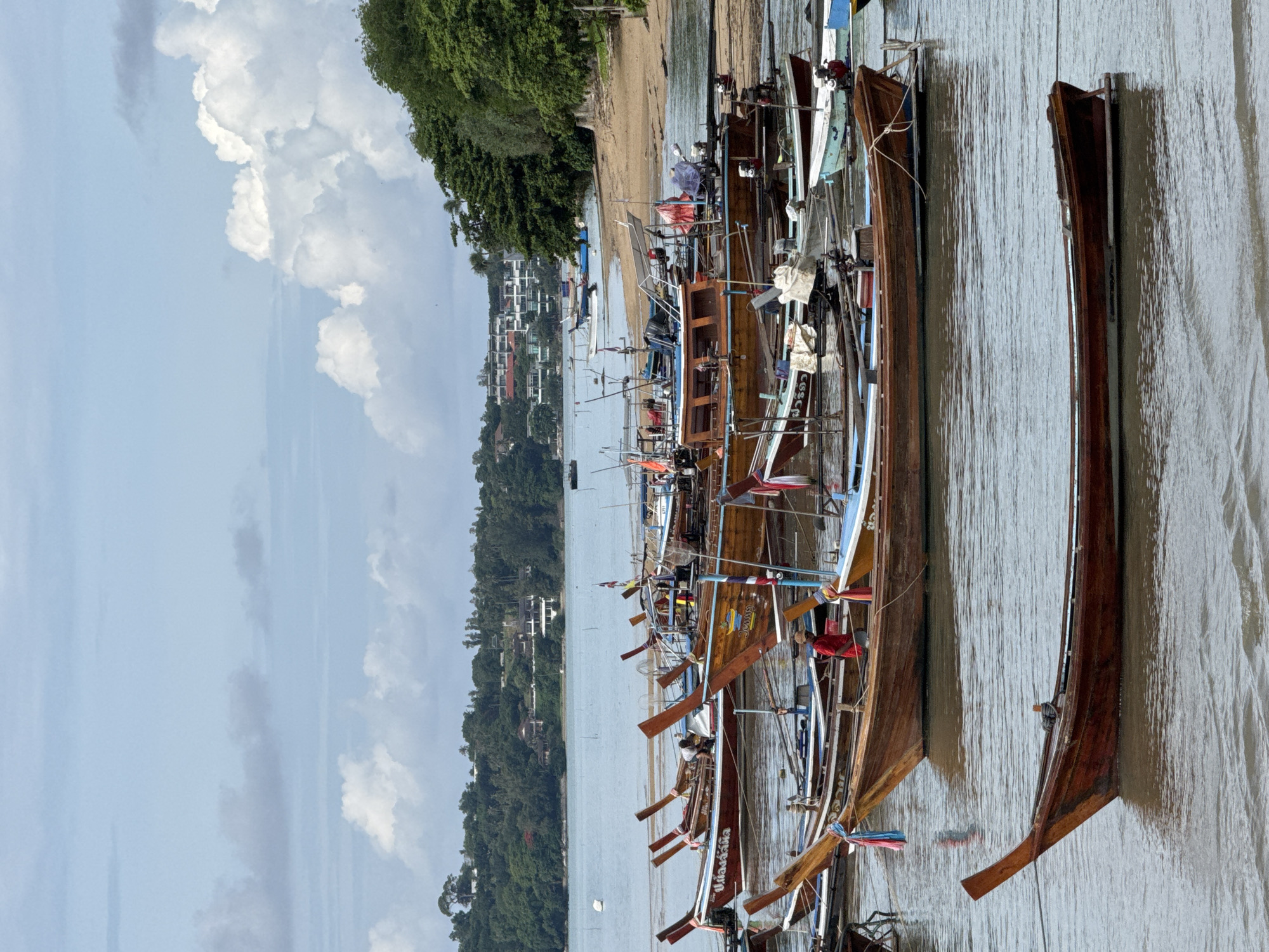 Longtail boats and a mosque along Rawai's quiet shoreline