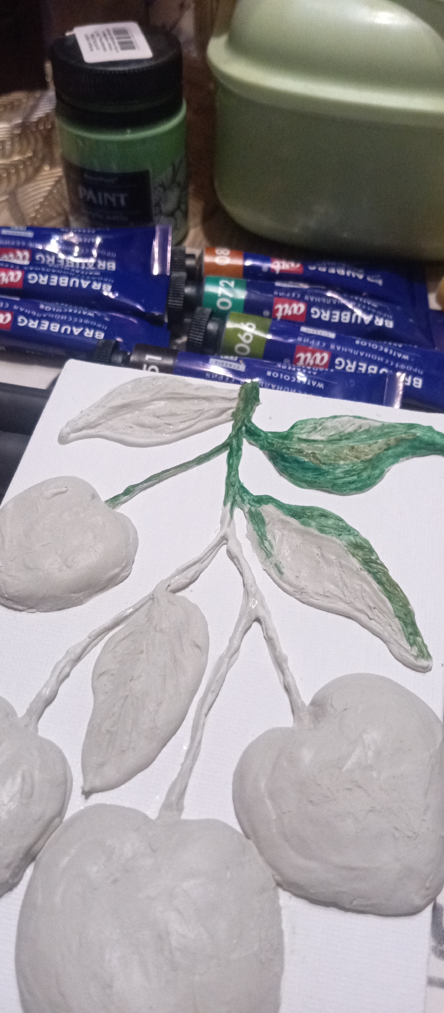 Artist works on clay apple sculpture with watercolors