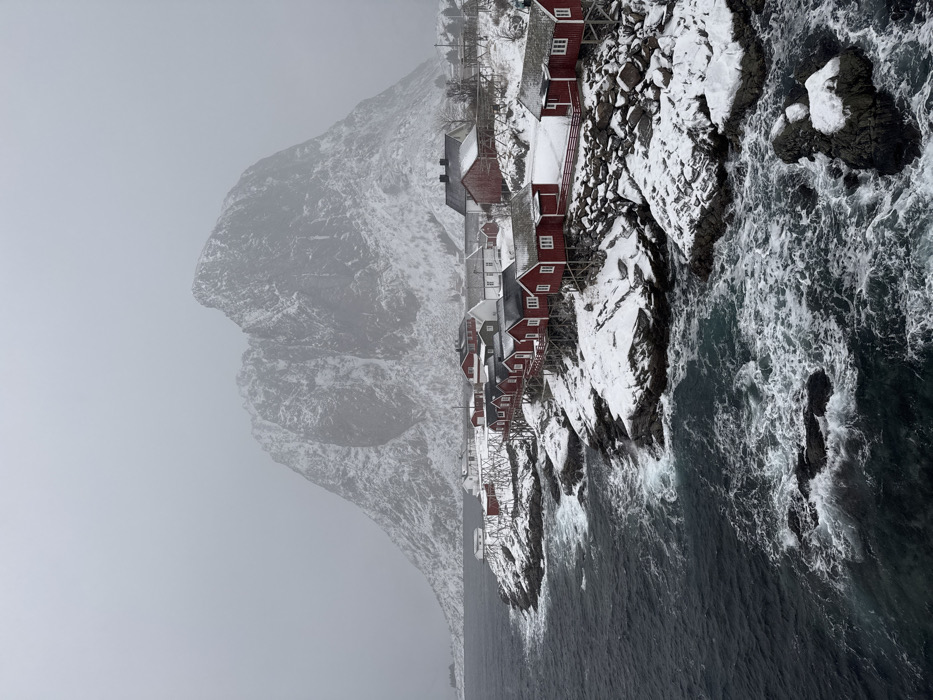 Snowplow clears roads during snowfall in Norwegian coastal village