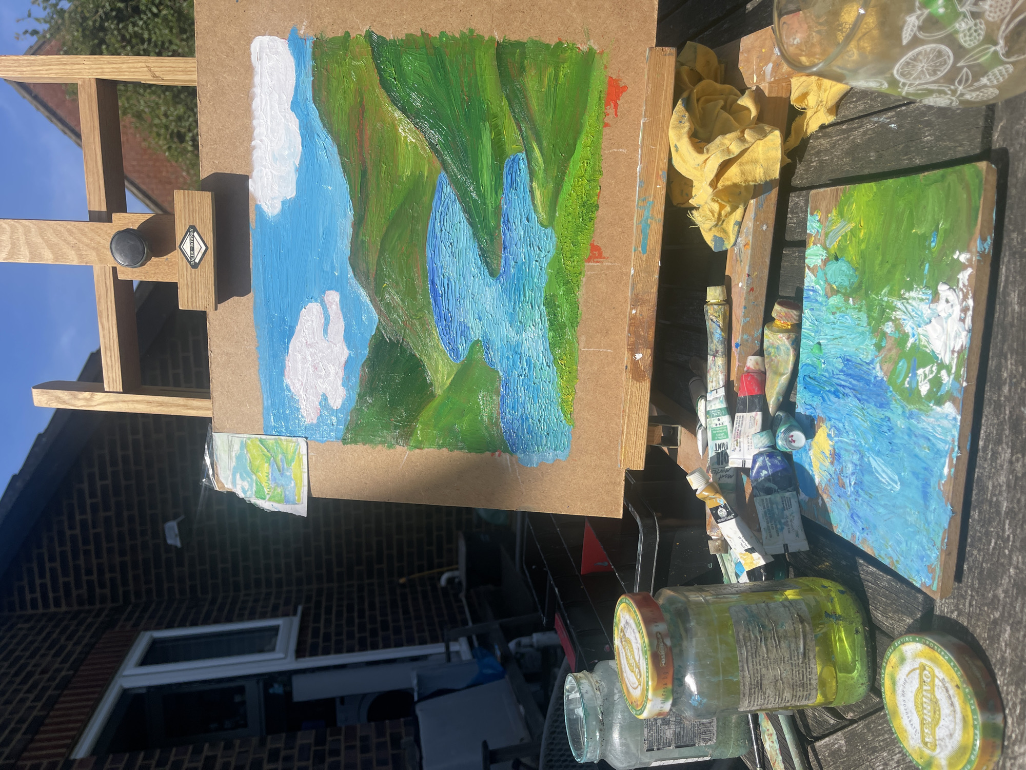 Artist paints waterfall landscape outdoors in Maidstone backyard