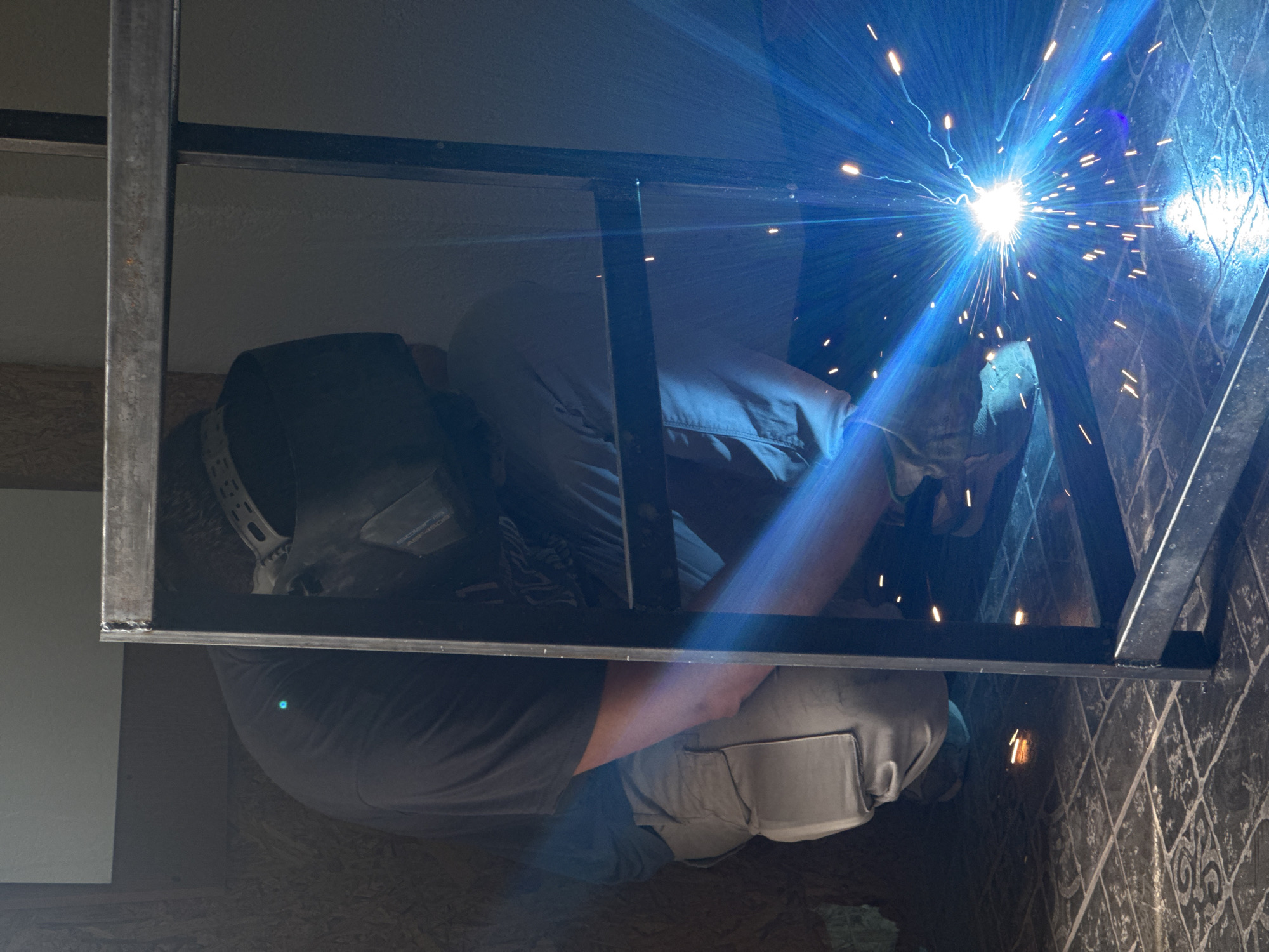 Workshop welding session with a motorcycle and stormy skies outside