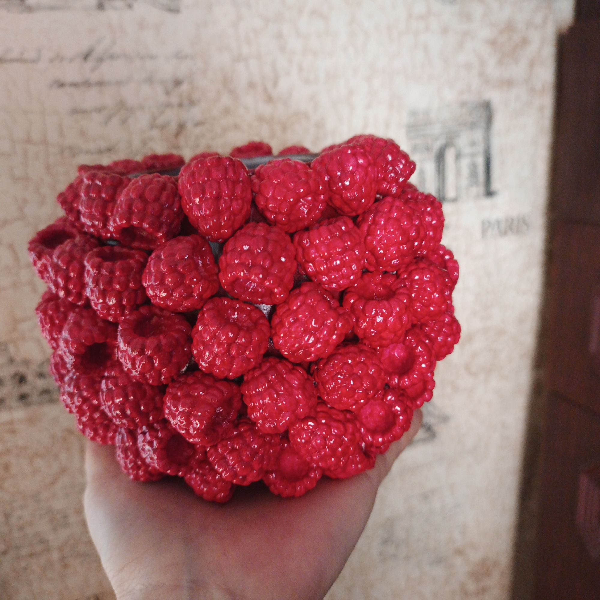 Holding a bright red raspberry-shaped plastic object in Russia