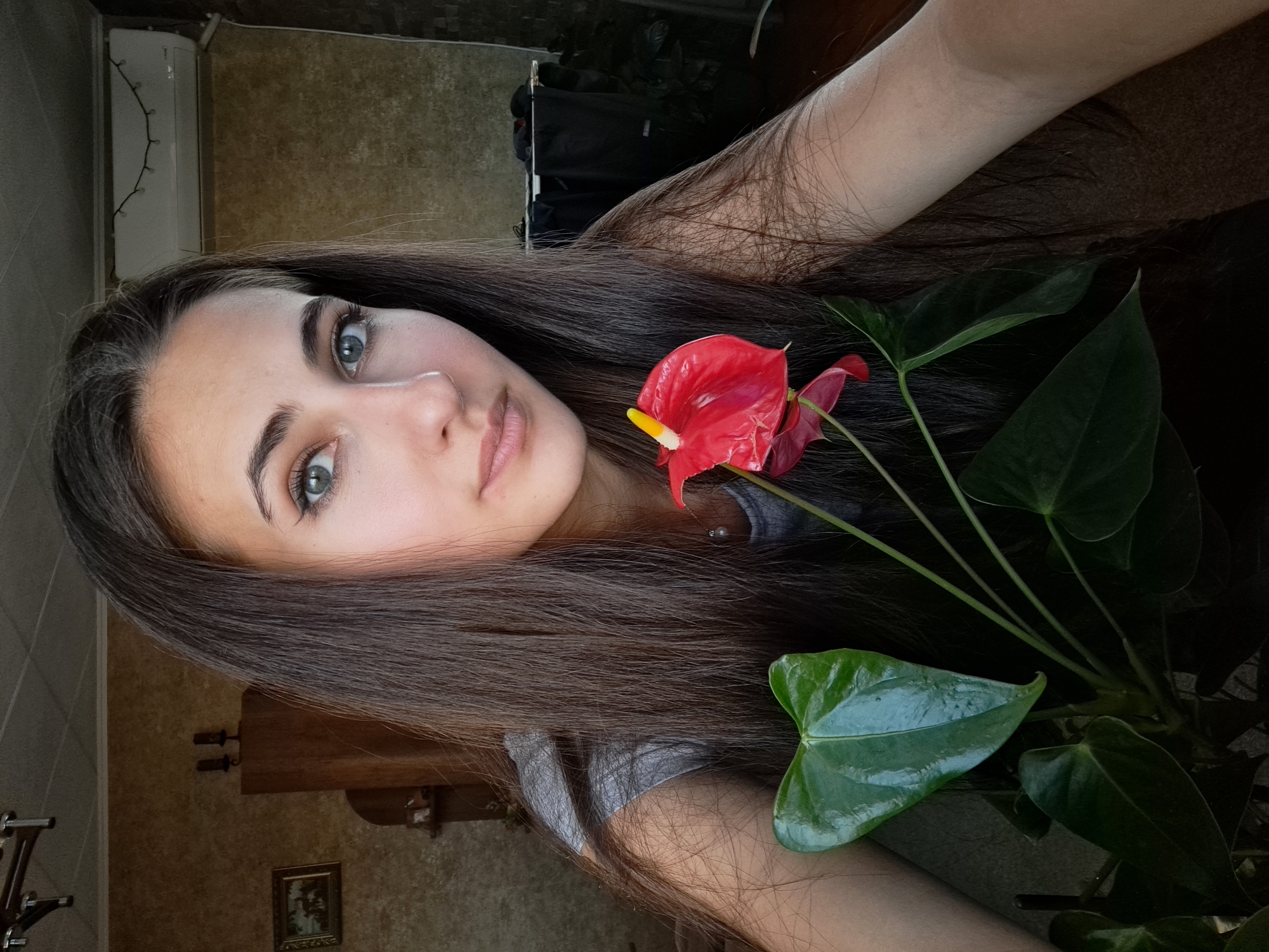 Woman poses with red flowers in Bulgarian home