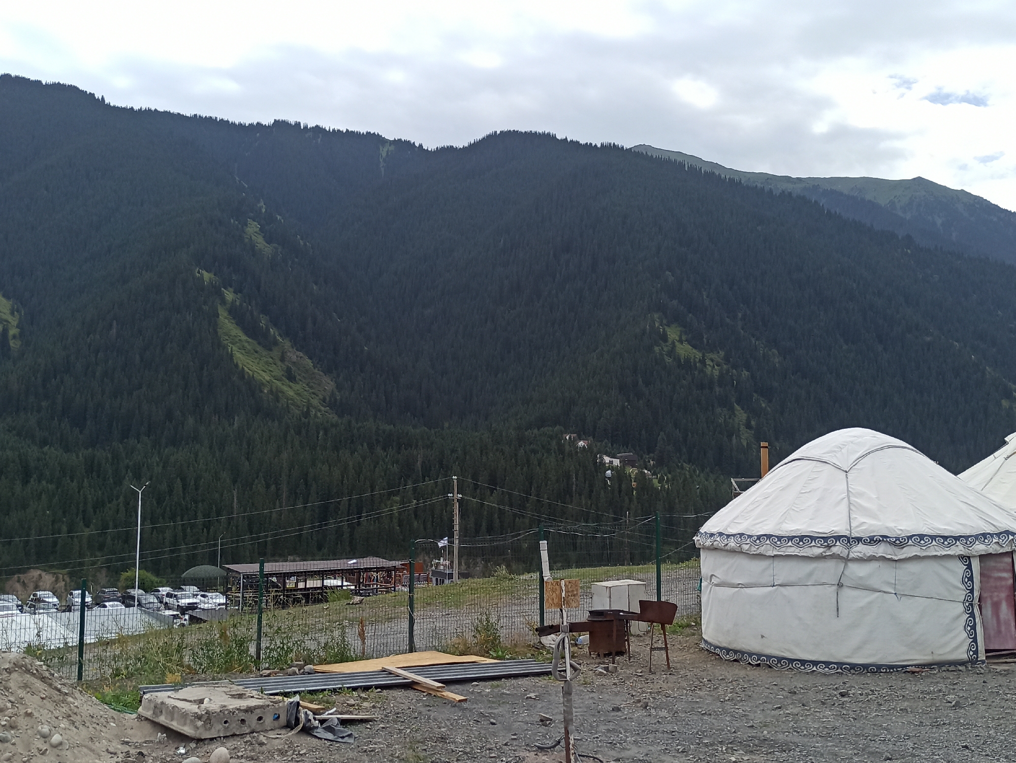 Yurt camp nestled below forested mountains in Kurmeti, Kazakhstan