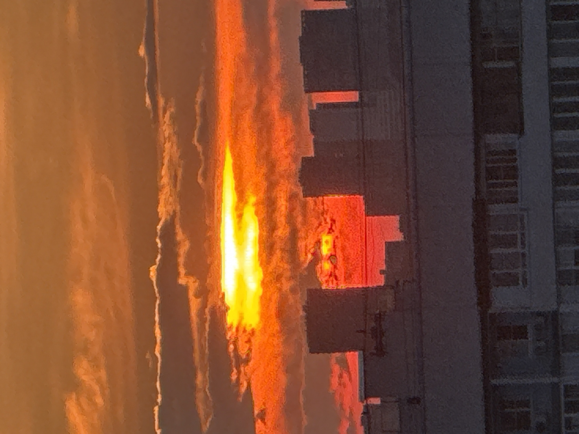 City sunset with a lit bridge and waterfront crowd