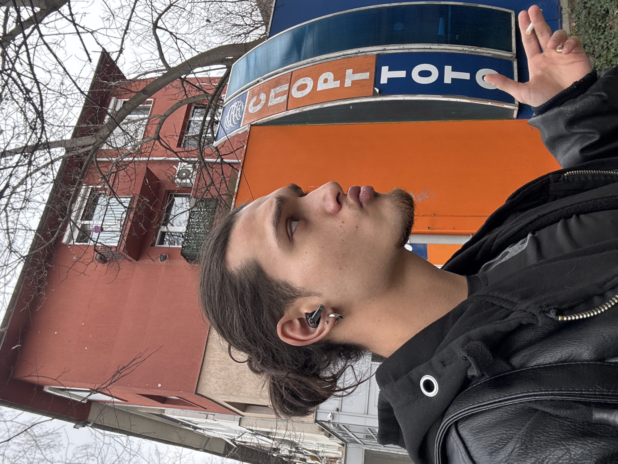 Man smoking cigarette outside Sport Toto building in Sofia
