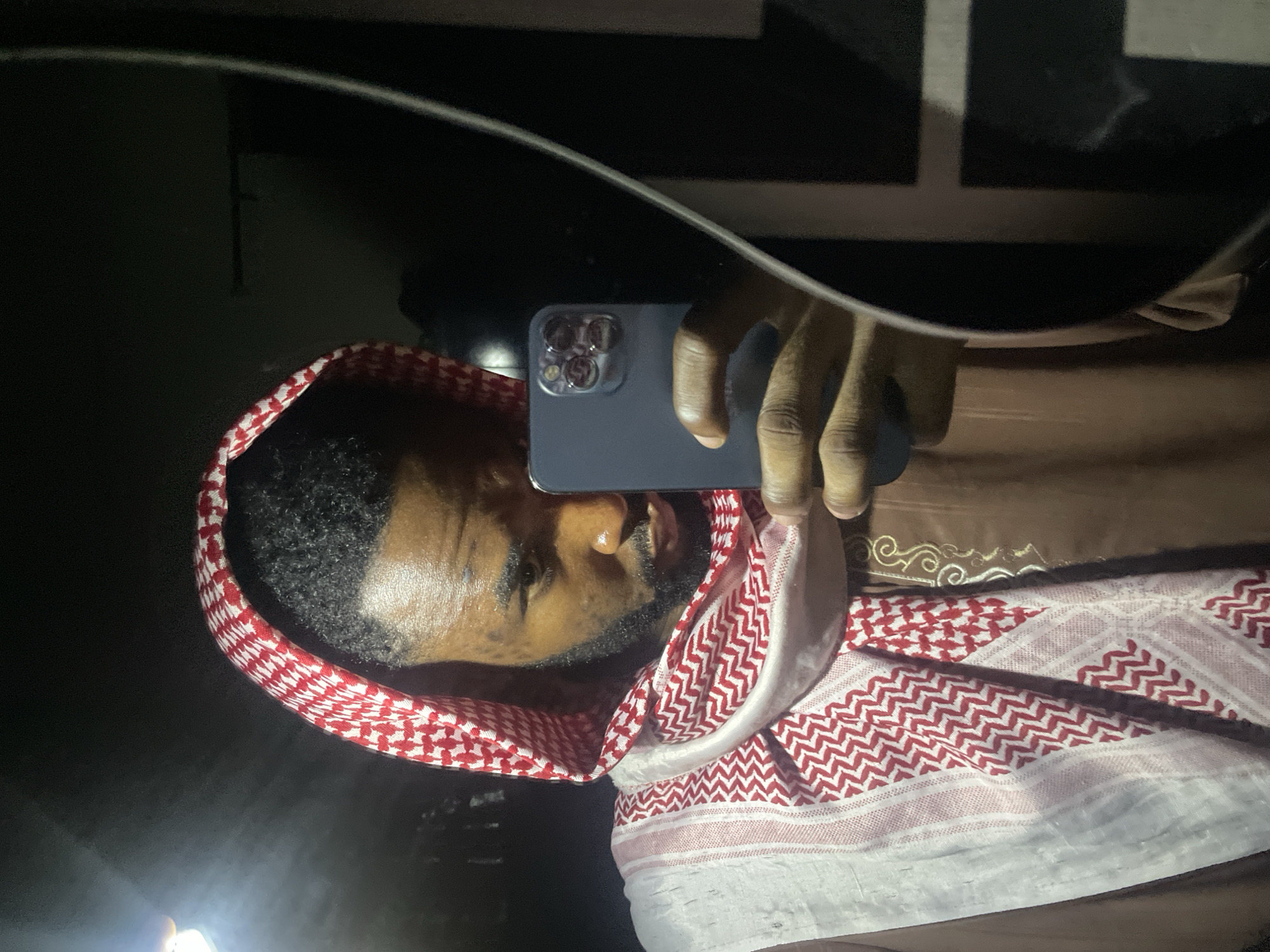 Man in keffiyeh takes multiple selfies in Lokoja