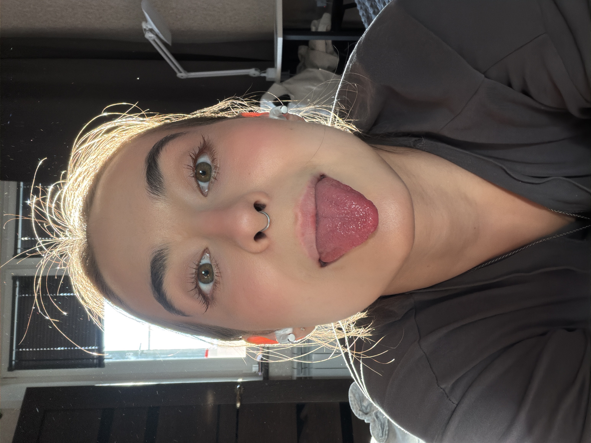Person takes playful selfies in sunny Krasnoyarsk room