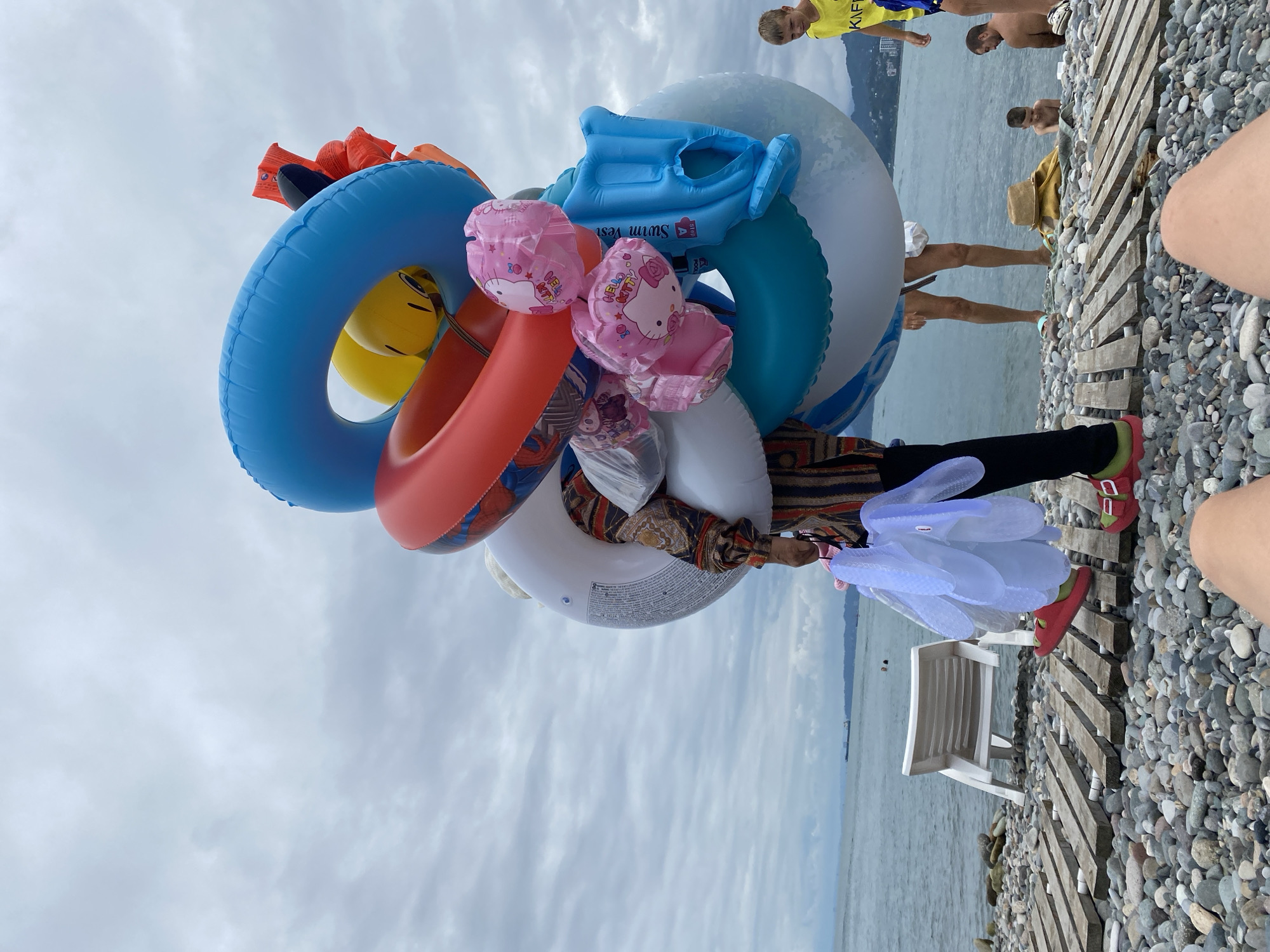 Cloudy morning on Batumi's pebble beach, inflatables in tow