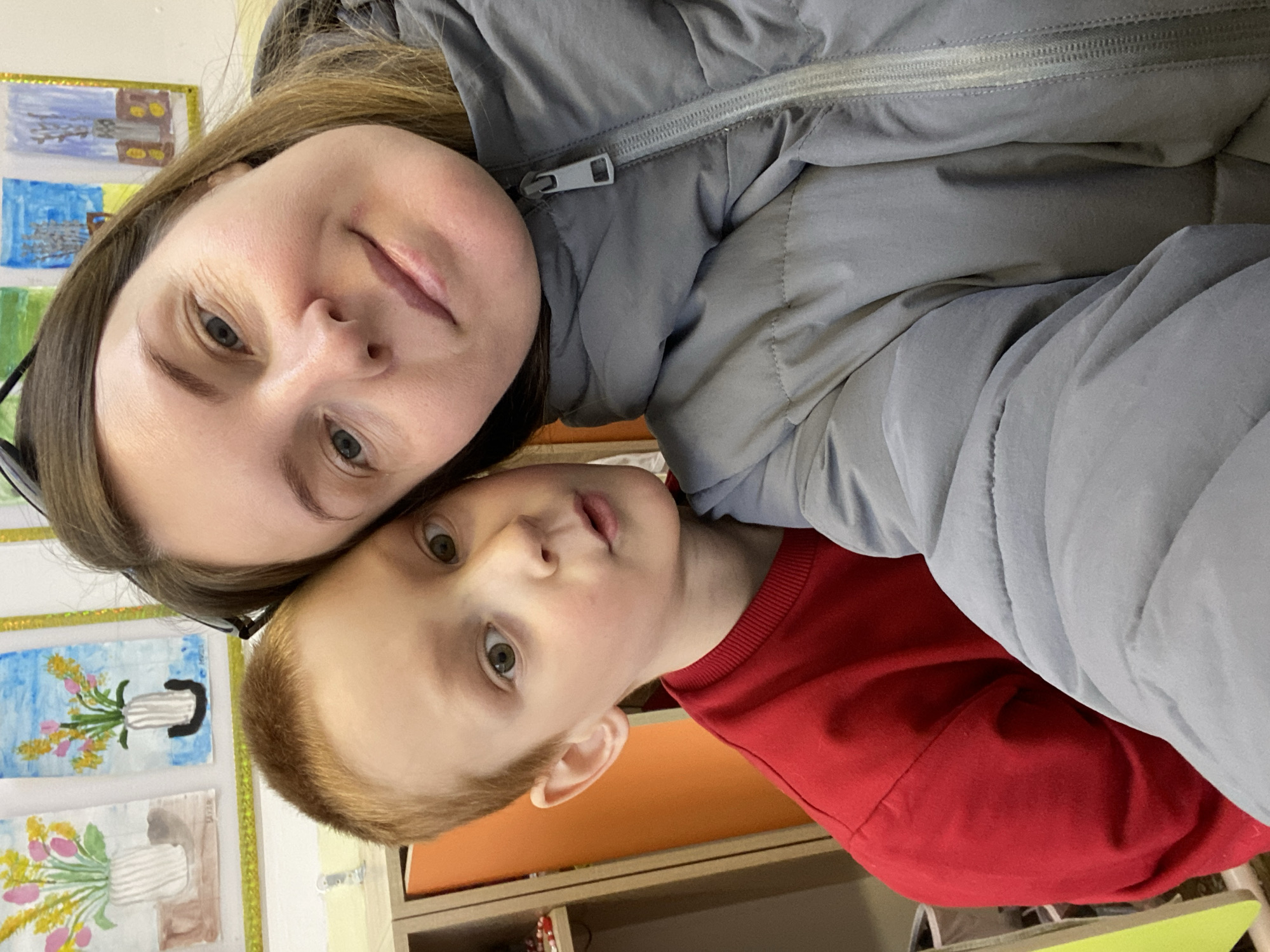 Woman and child share moment near school art display