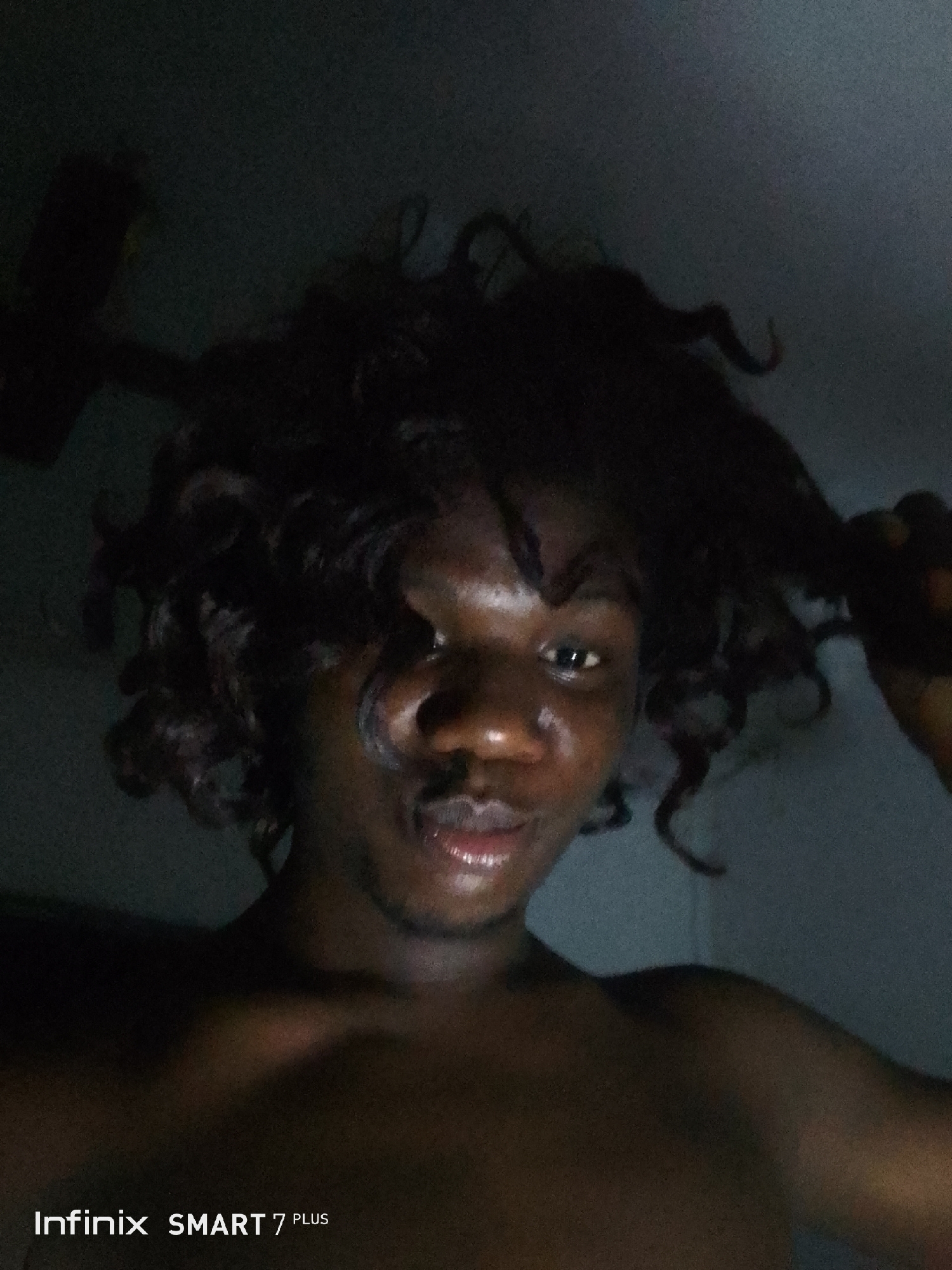 Young adult photographed in low-light selfie session with face paint