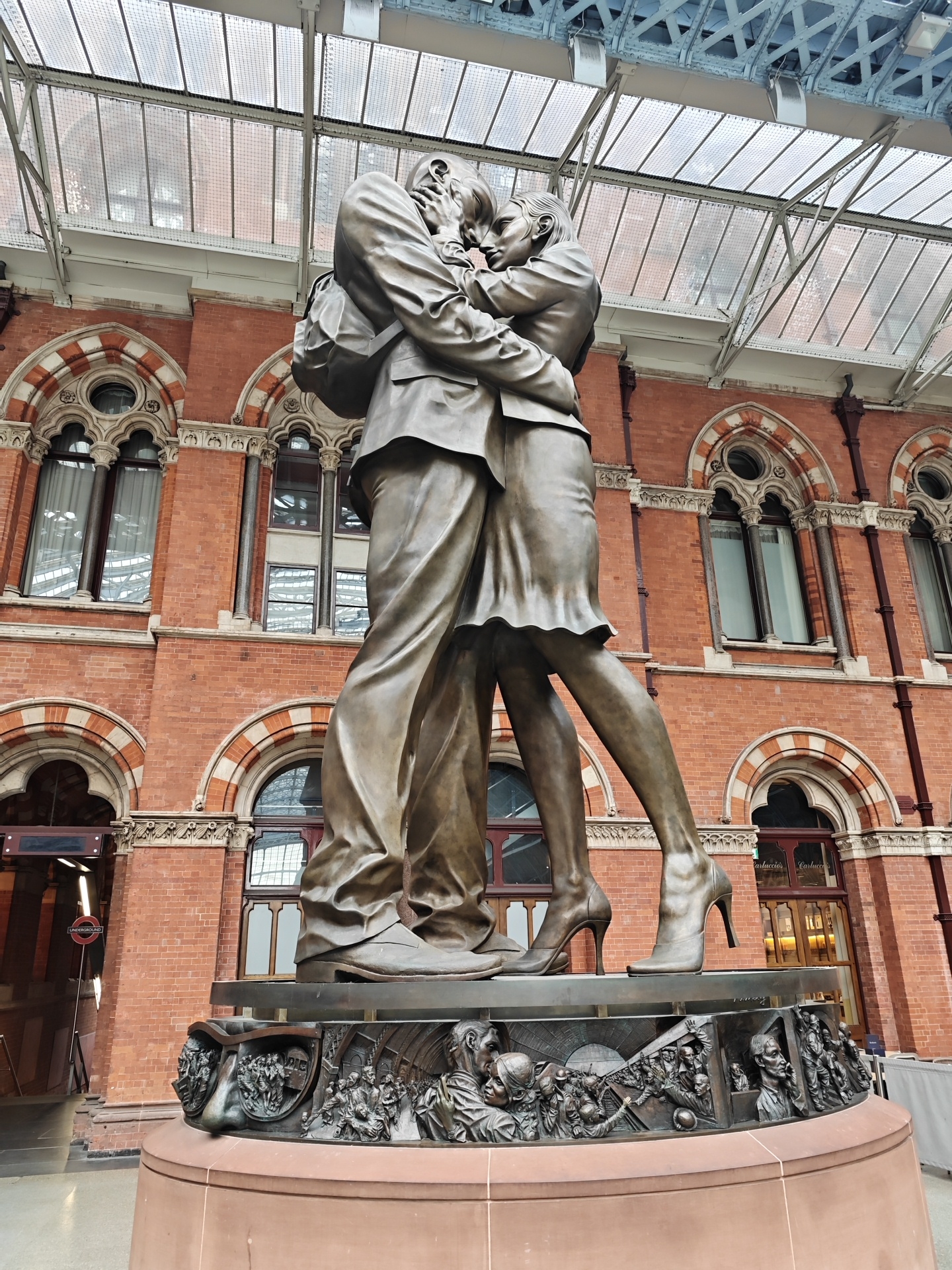 Bronze kissing couple statue documented at St Pancras Station