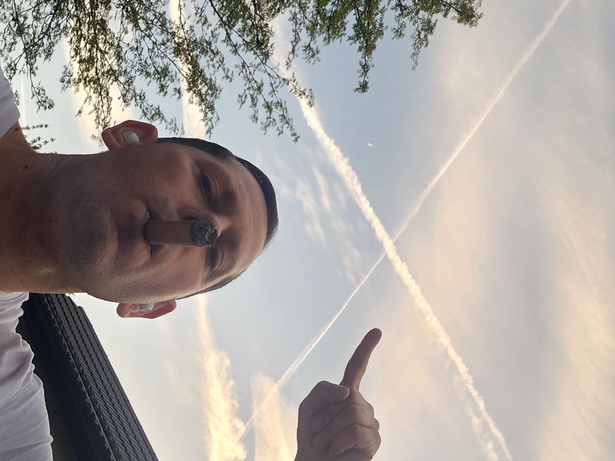 Man smoking cigar with earbuds observed in London