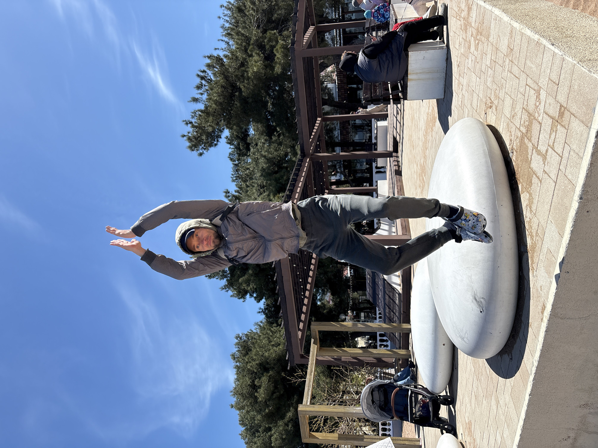 People perform jumping poses at Gelendzhik beach promenade