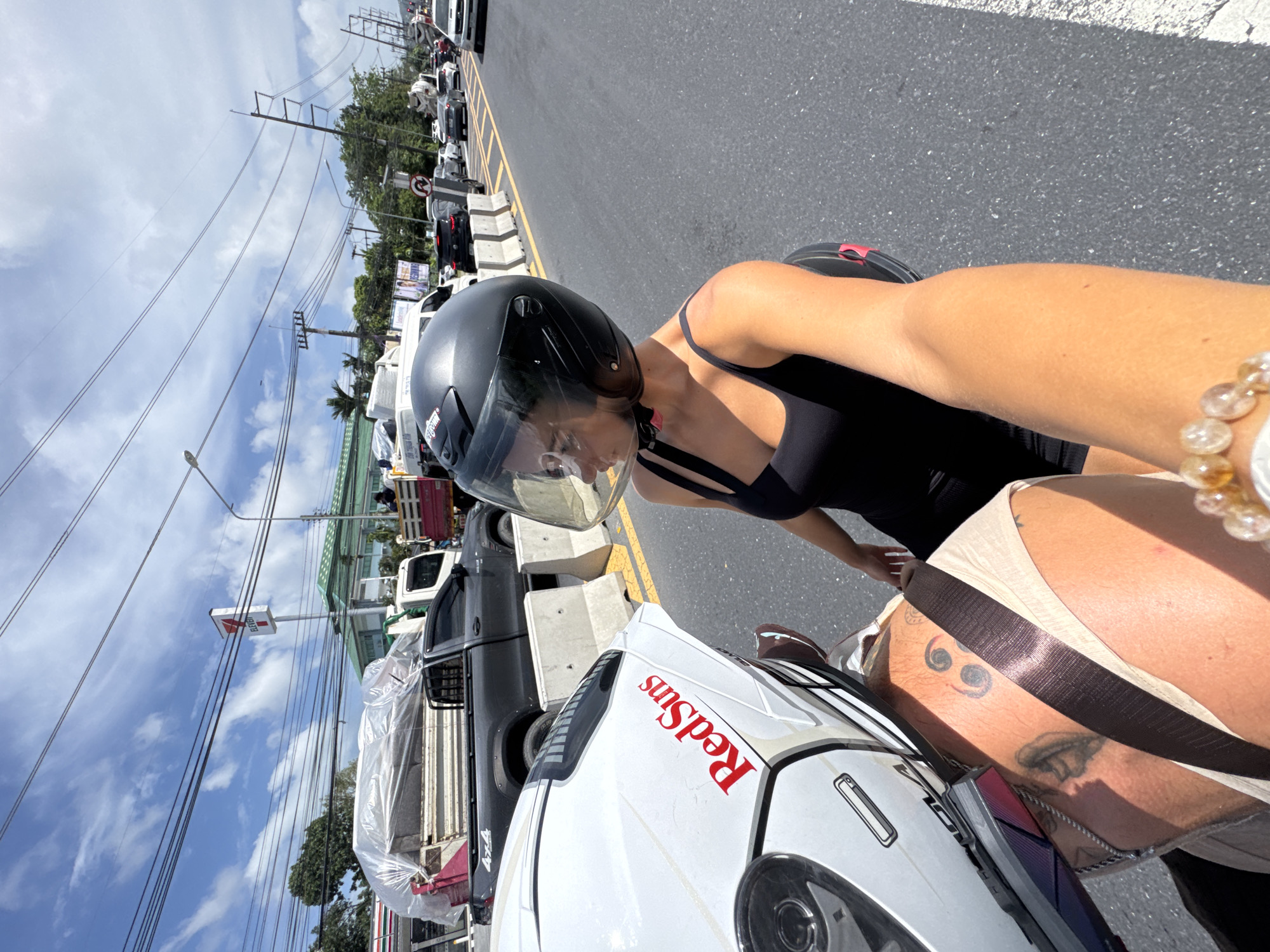 Woman on motorcycle observed in morning traffic in Wichit, Thailand