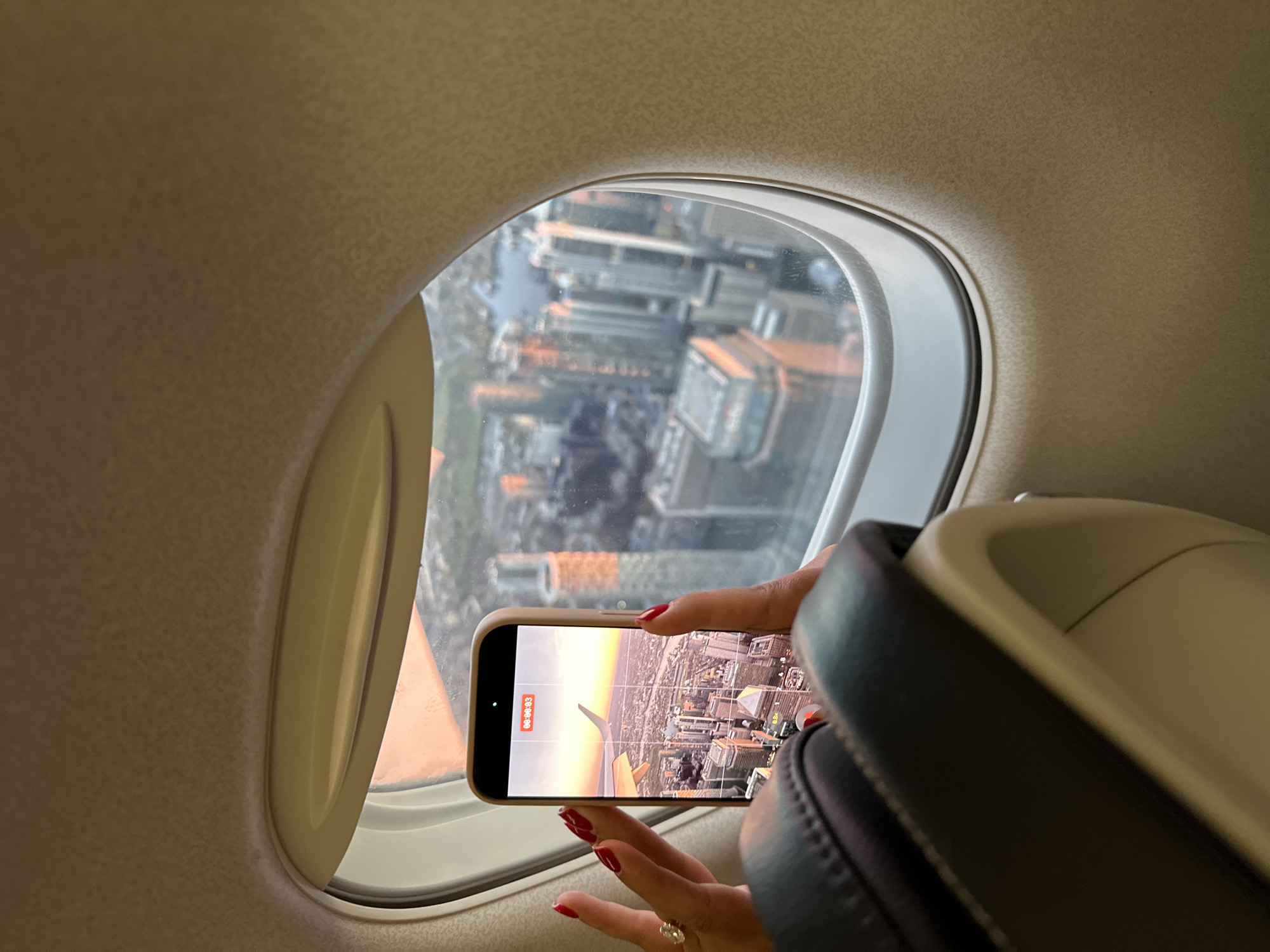 Passenger photographs view from airplane window with mobile phone