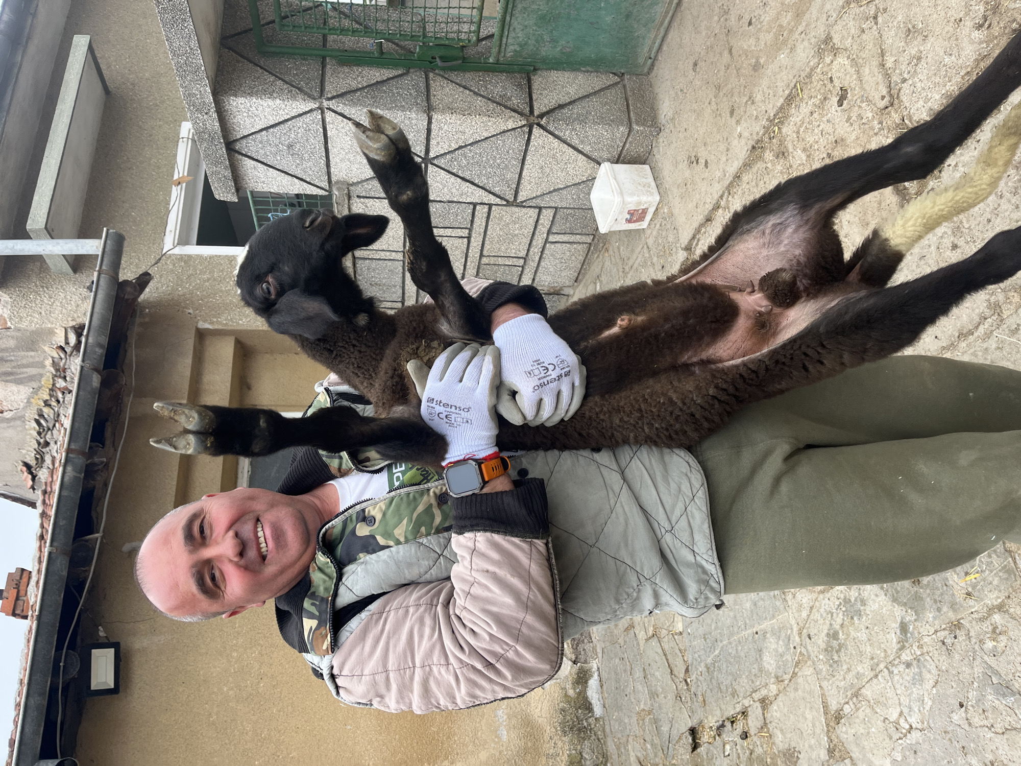 Man holds black lamb in Bulgarian village