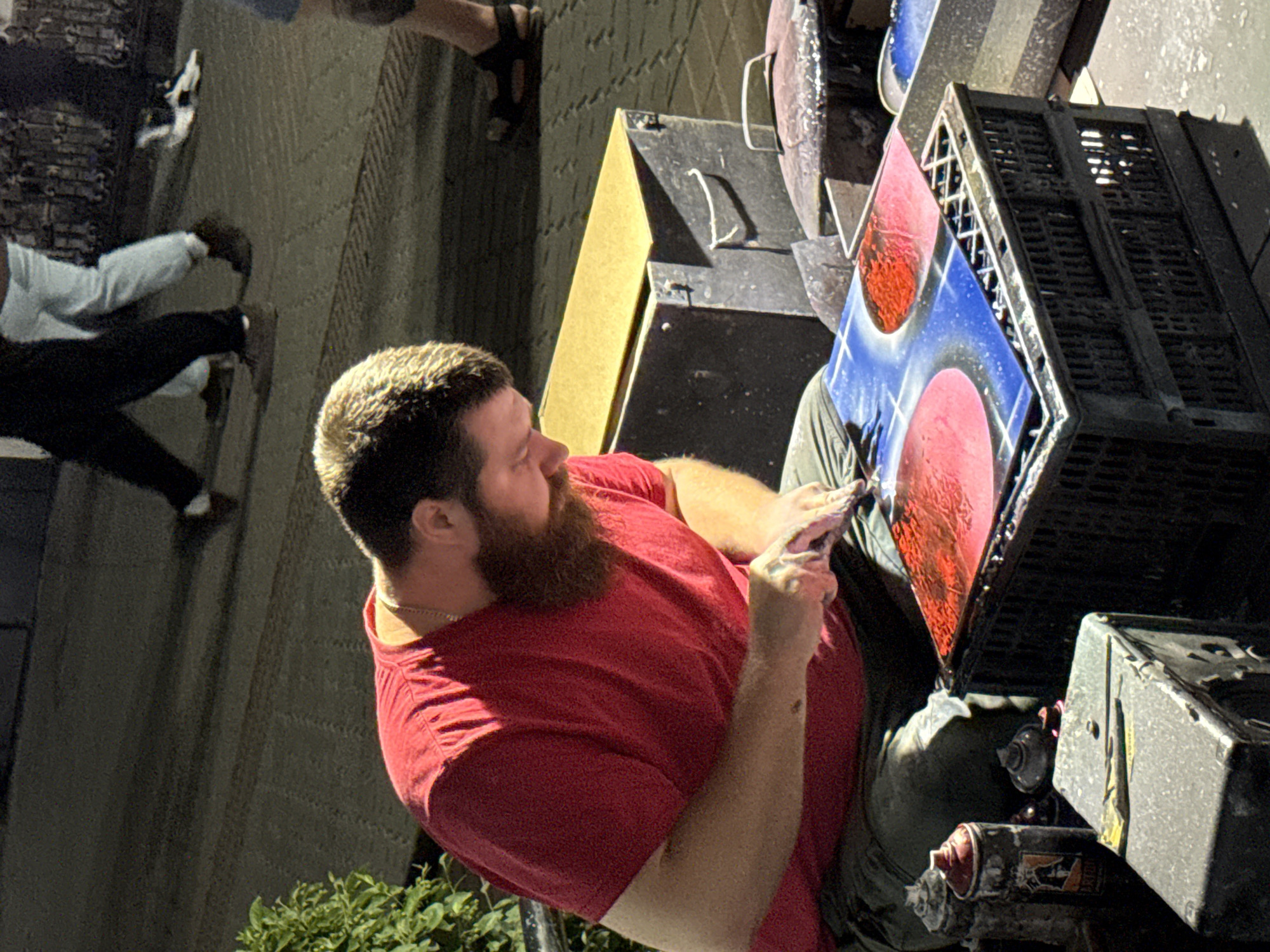 Street artist spray paints and displays work outdoors in Kazan