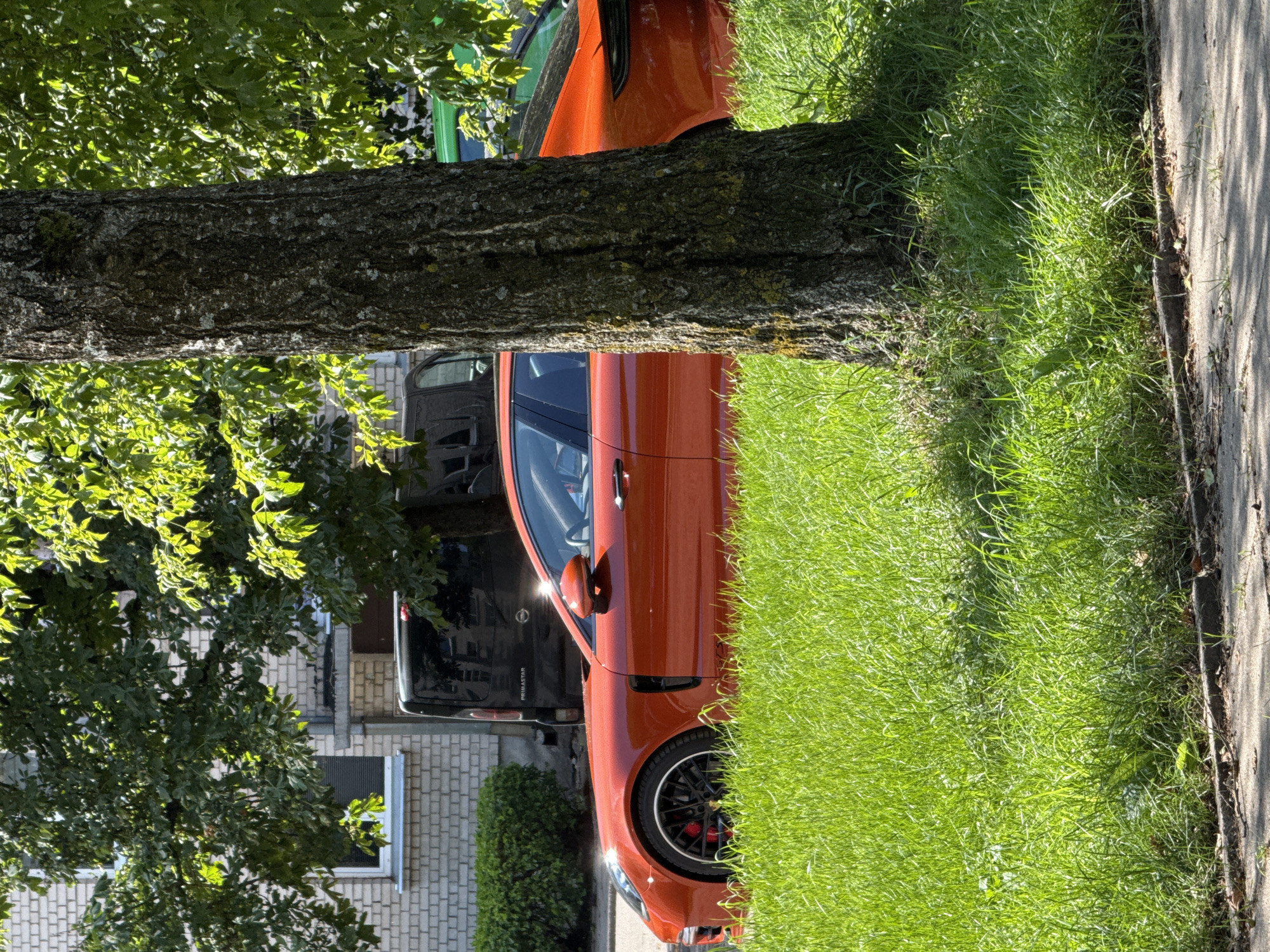 Orange Porsche Panamera parked streetside in Rudamina, Lithuania