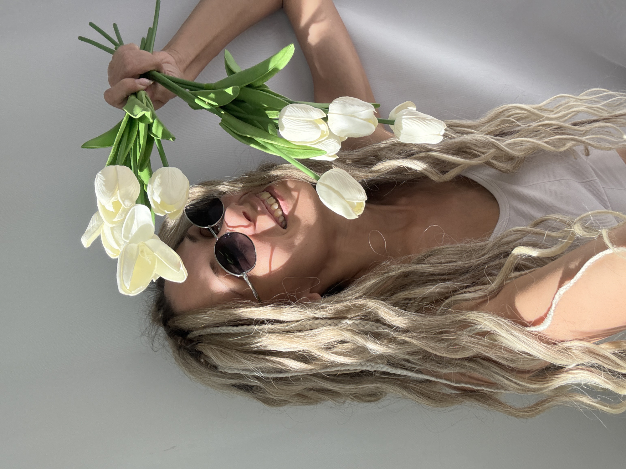 Woman with braided blonde hair photographed lying down