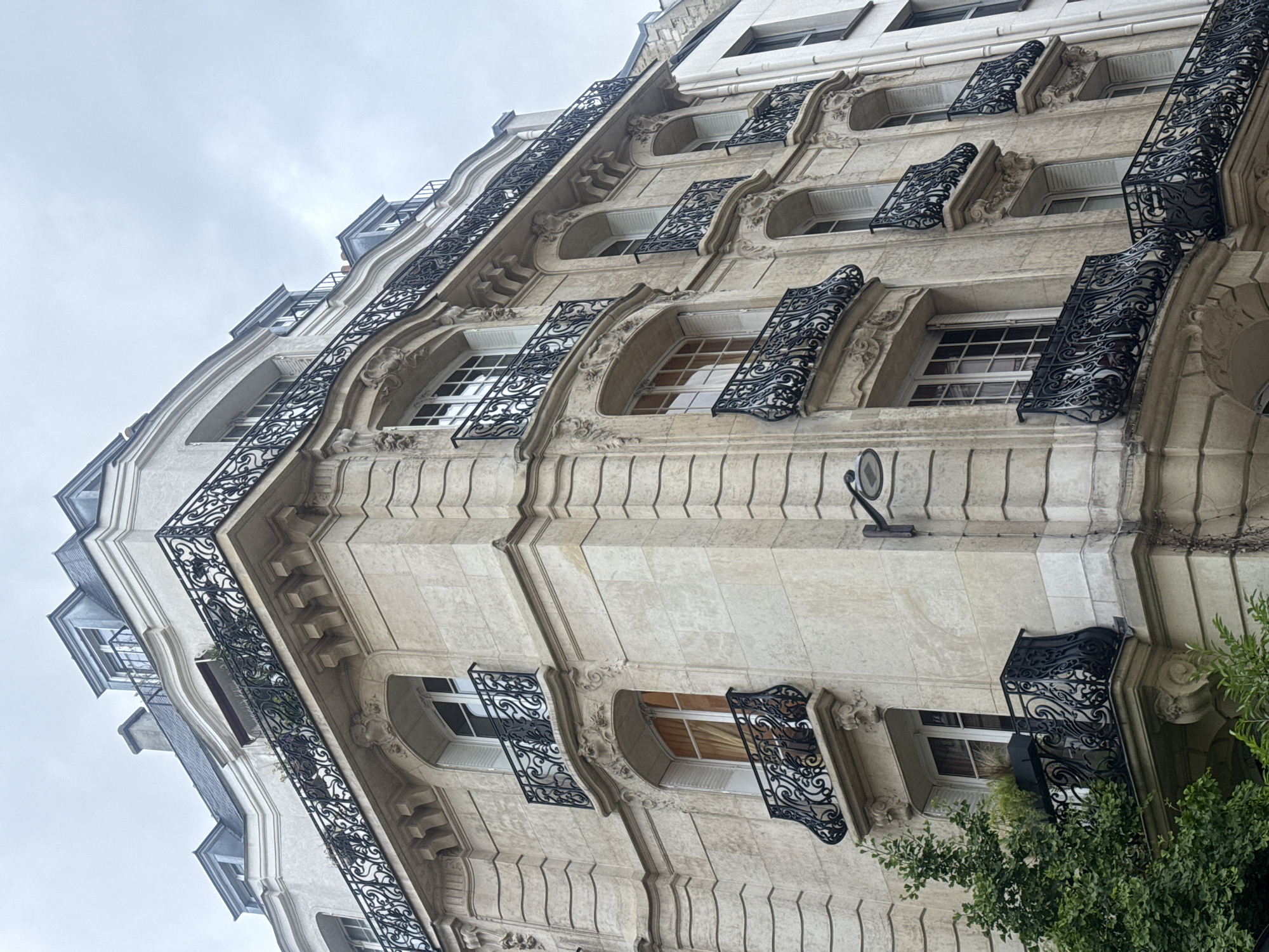 Woman takes elevator selfie near ornate Parisian building