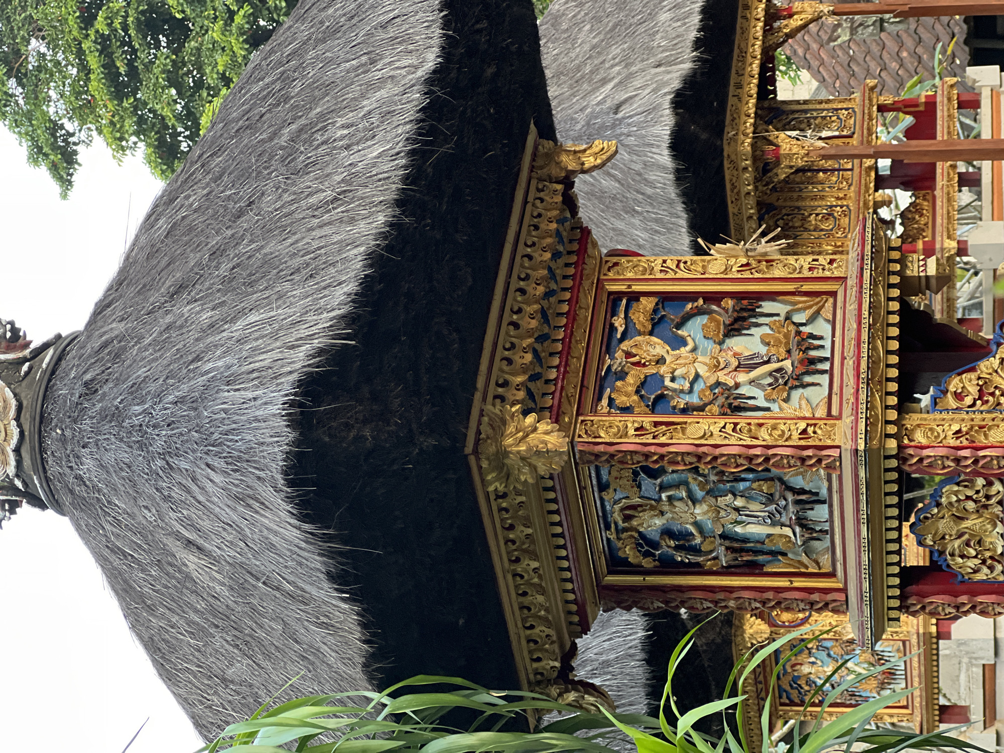 Cat rests on stone ledge near traditional architecture in Ubud