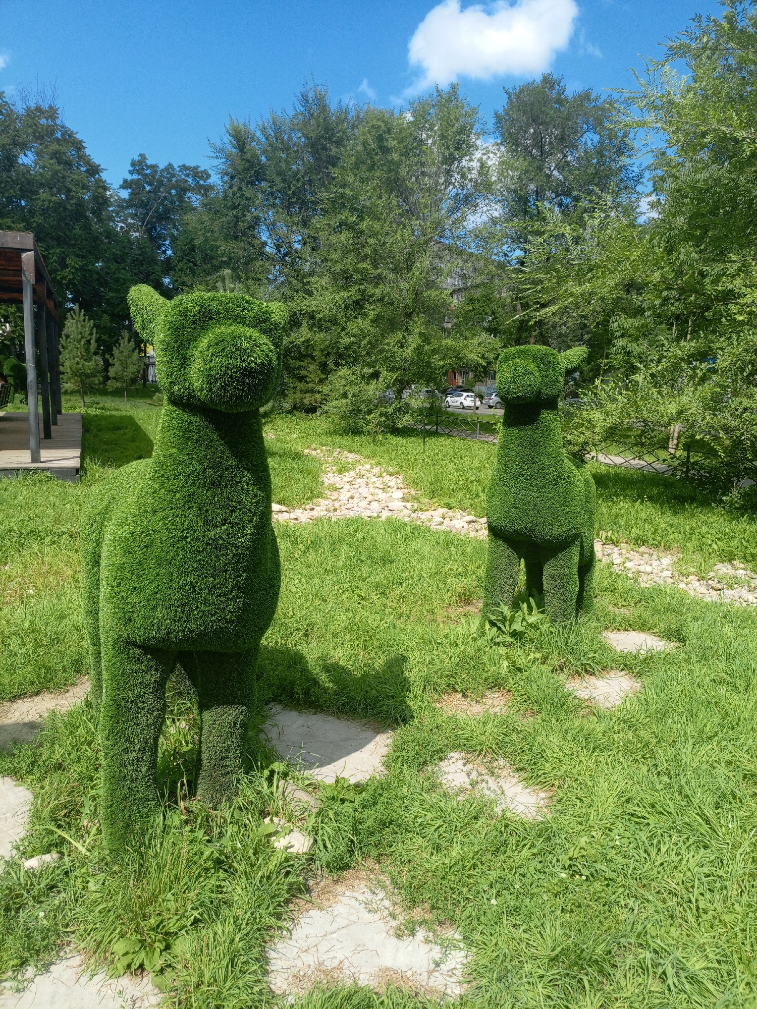 Topiary animal sculptures fill a green park setting