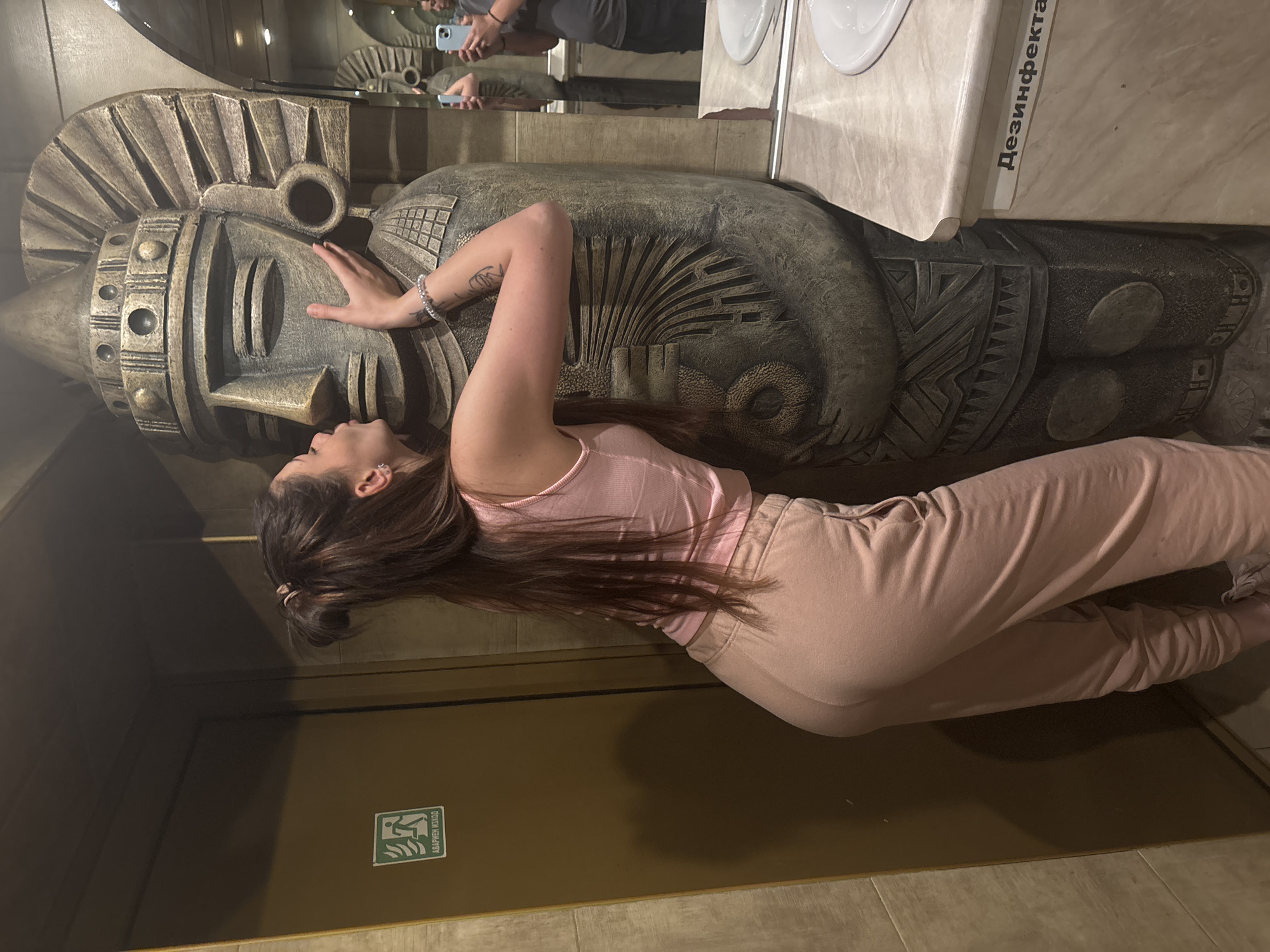 Woman poses with ornate sculpture in Sofia public building